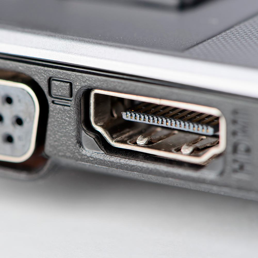 Nahaufnahme eines Laptops mit HDMI- und VGA-Anschlüssen an der Seite.