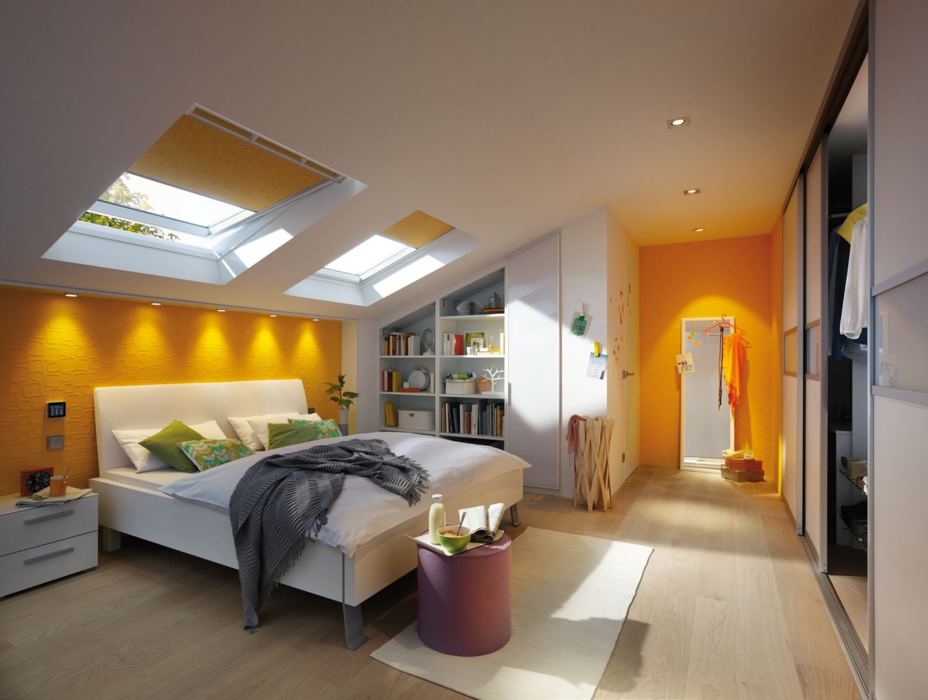 Ein Schlafzimmer mit weißem Bett, orangefarbener Wand, Bücherregalen und Tageslicht durch Dachfenster.