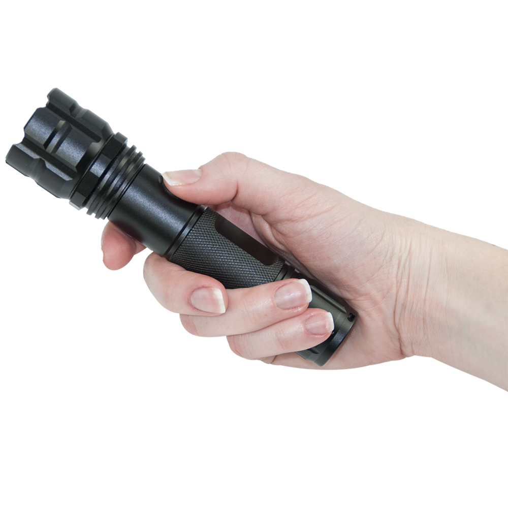 Eine Hand, die eine schwarze Taschenlampe mit strukturiertem Griff hält, wobei das Lichtende nach oben zeigt.