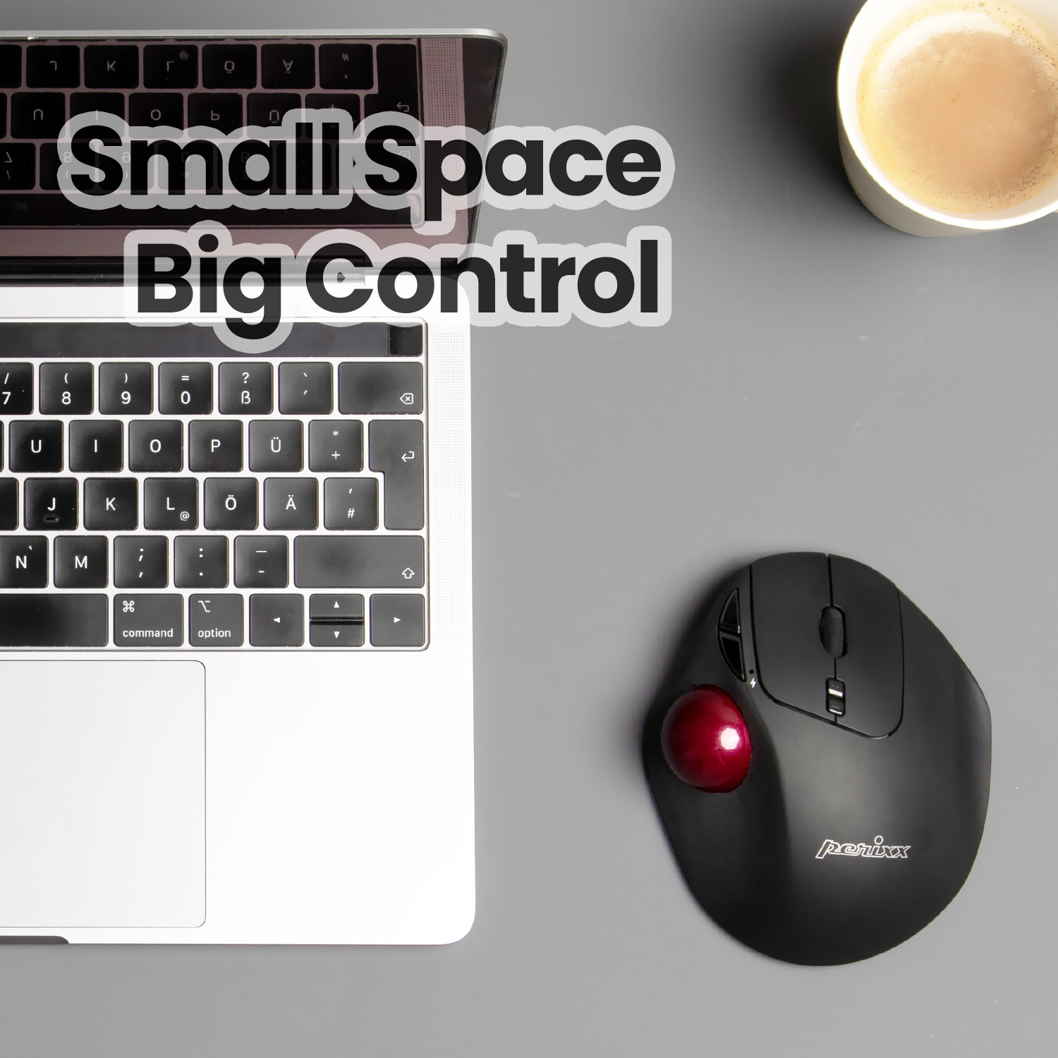 Laptop, Trackball-Maus und eine Tasse Kaffee auf grauer Oberfläche.