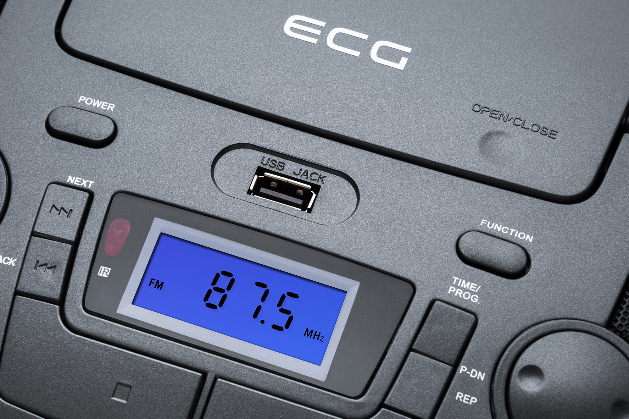 Nahaufnahme eines schwarzen Radios mit blauem Display, das 87,5 MHz anzeigt. Knöpfe und USB-Buchse sichtbar.