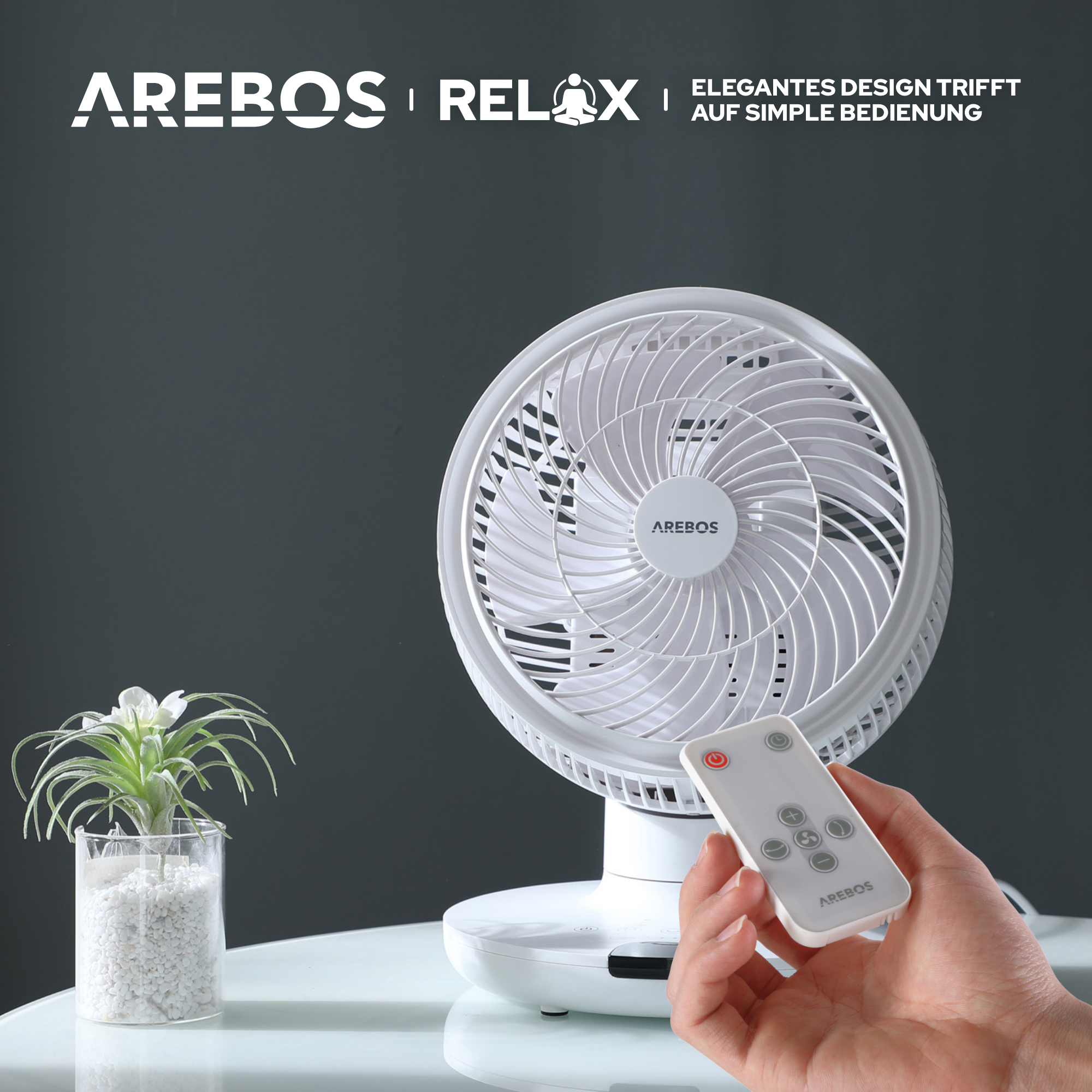 Weißer Ventilator mit Fernbedienung. Der Ventilator hat einen weißen Sockel, einen weißen Ventilator und steht auf einem weißen Tisch.