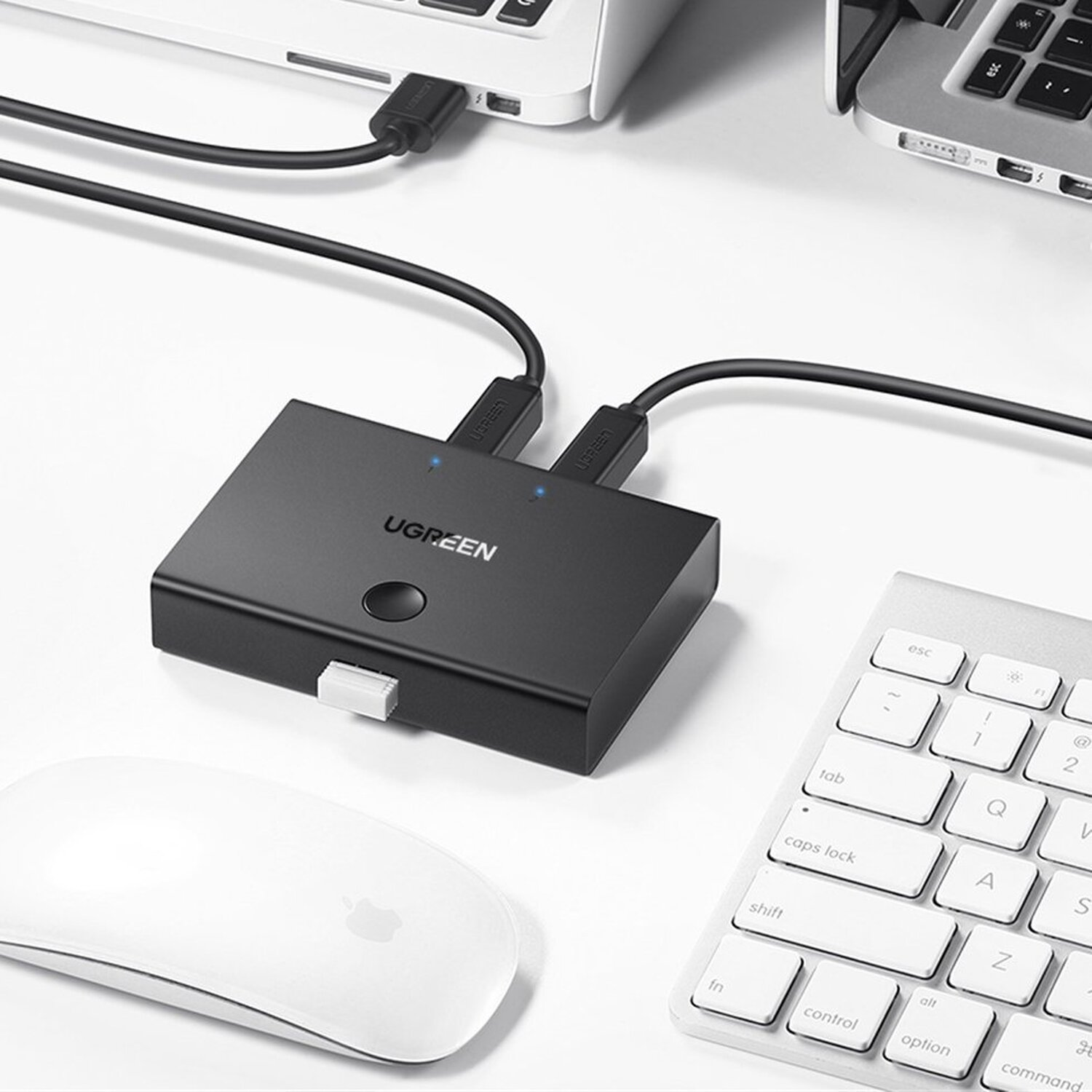 Ein schwarzer UGREEN USB-Hub, der an Laptops, eine Tastatur und eine Maus angeschlossen ist.