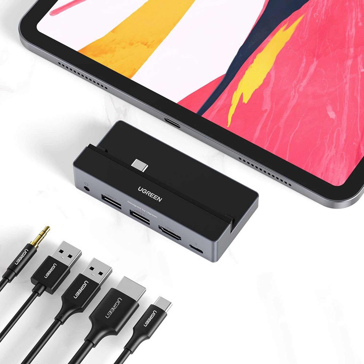 Tablet and black UGREEN hub with cables, including USB and HDMI, on a white surface.