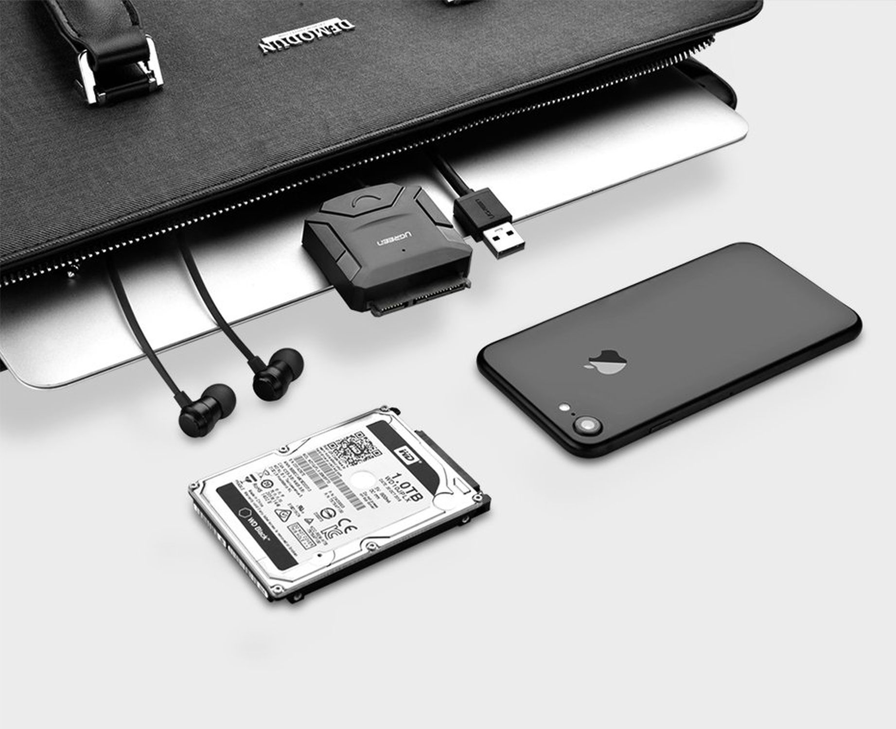 Torba na laptopa z laptopem, dyskiem twardym, telefonem i słuchawkami.