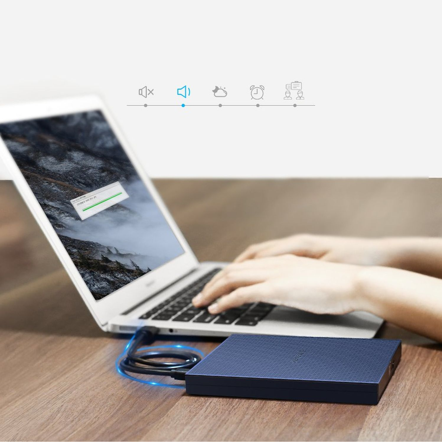 Ein Laptop mit angeschlossener externer Festplatte auf einem Holztisch.