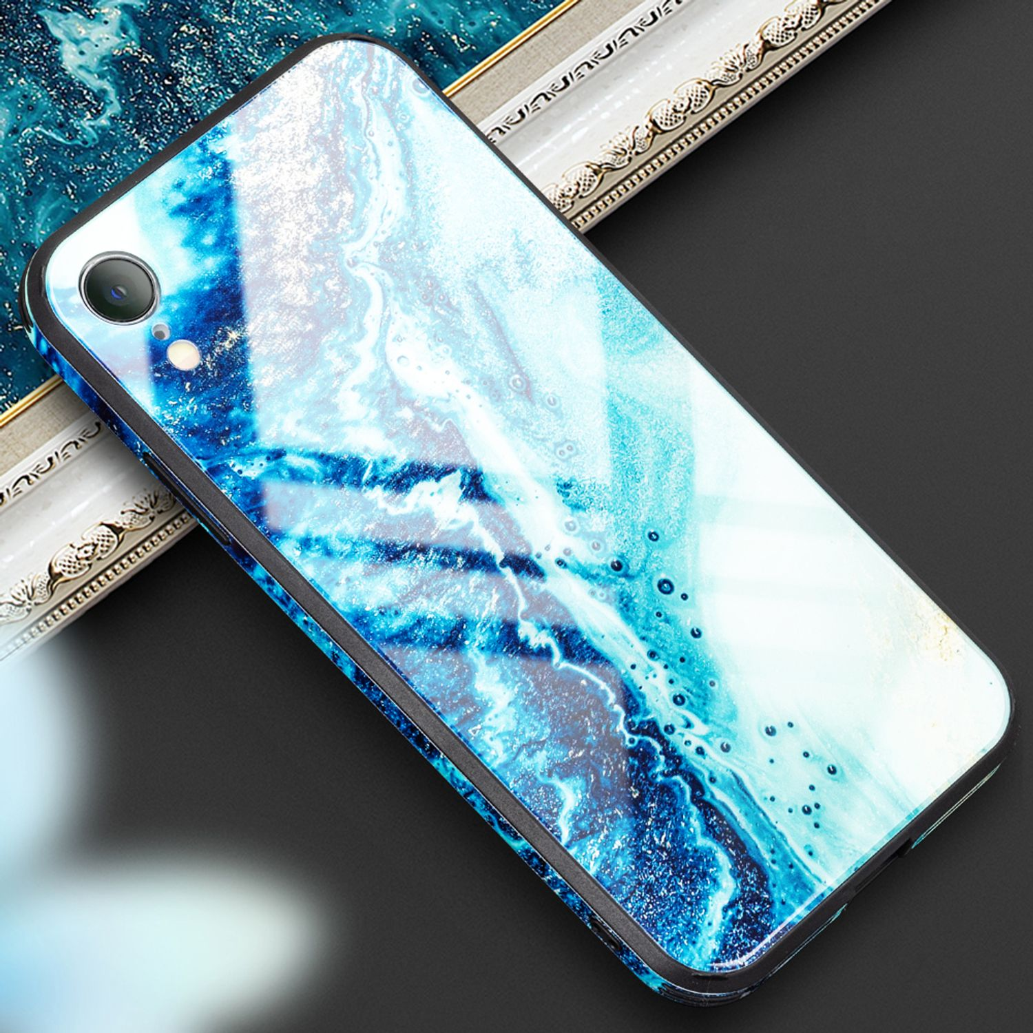 Eine Handyhülle mit blauem Marmordesign. Der Hintergrund ist schwarz und hat einen silbernen Rahmen.