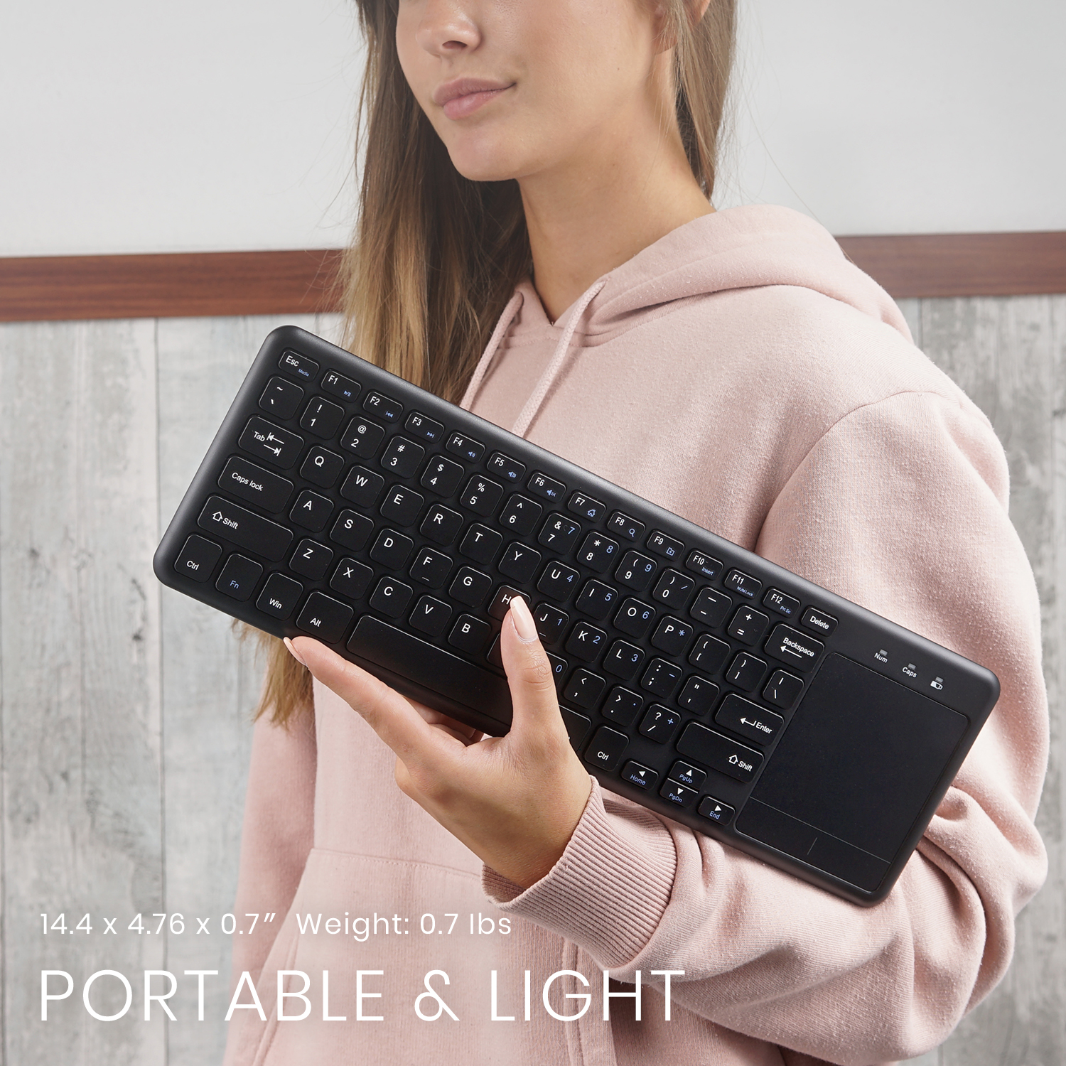 Eine Frau hält eine schwarze Tastatur mit Touchpad, darunter der Text „PORTABLE & LIGHT“.
