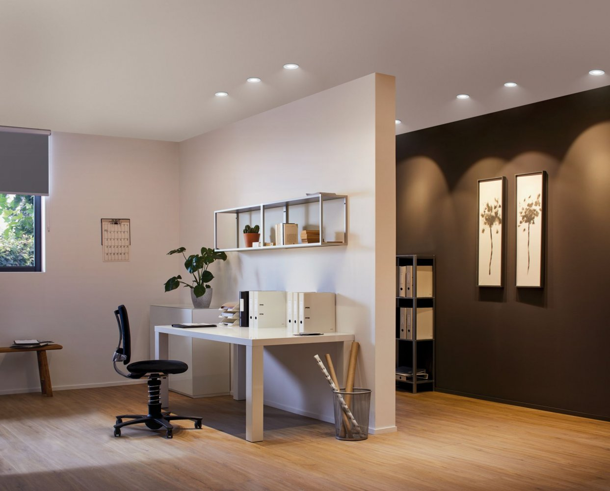 Modernes Büro mit weißem Schreibtisch, schwarzem Stuhl und Deckeneinbauleuchten.
