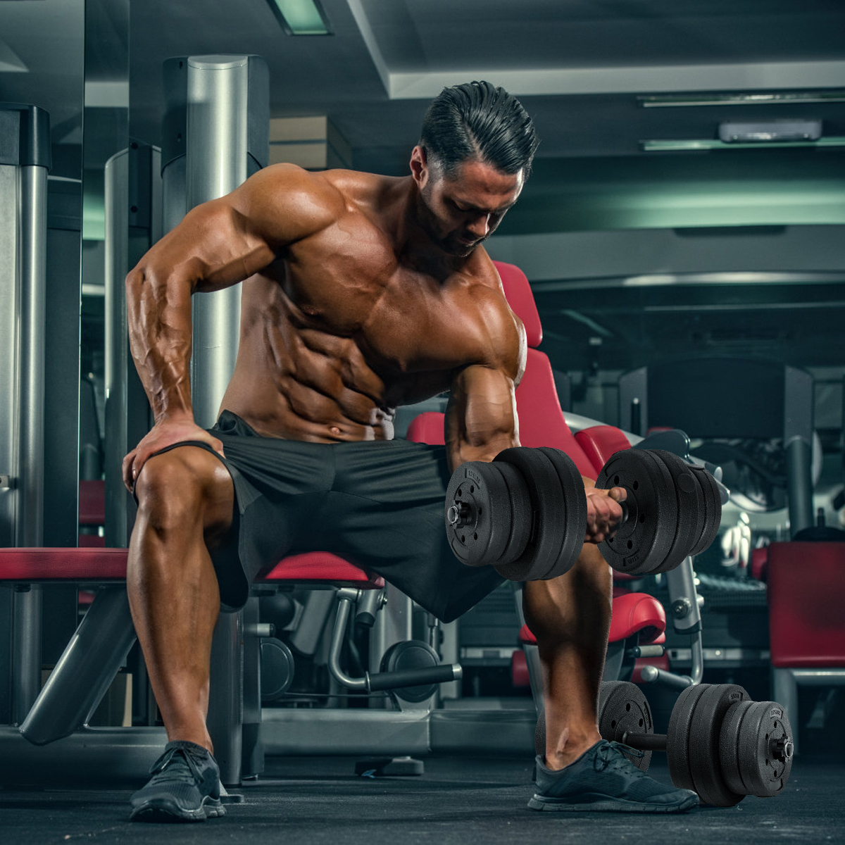 Mann im Fitnessstudio, der Gewichte hebt. Er ist muskulös, trägt Shorts und sitzt auf einer roten Bank.