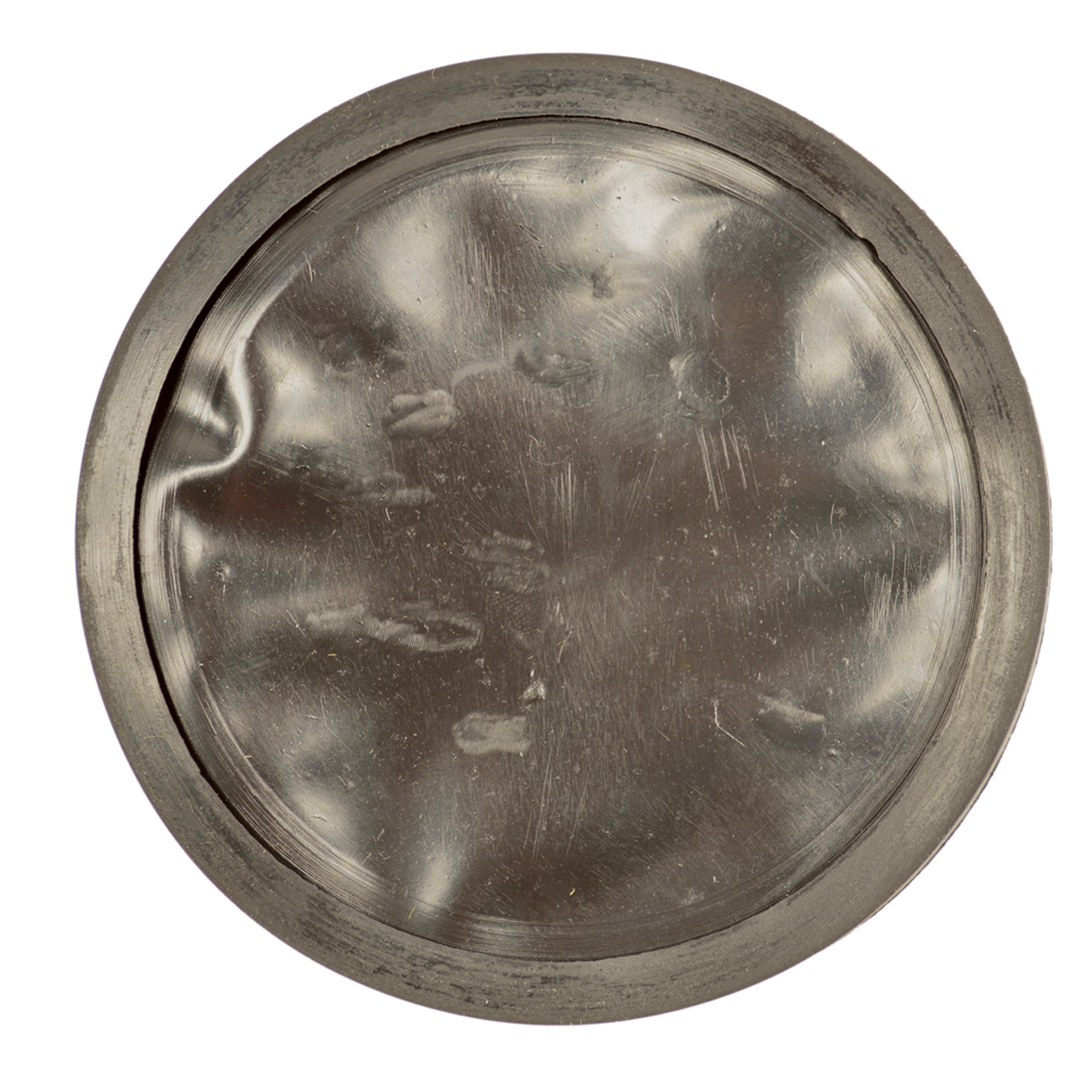 Kreisförmiger, metallischer, zerkratzter und verbeulter Deckel, isoliert auf Weiß.