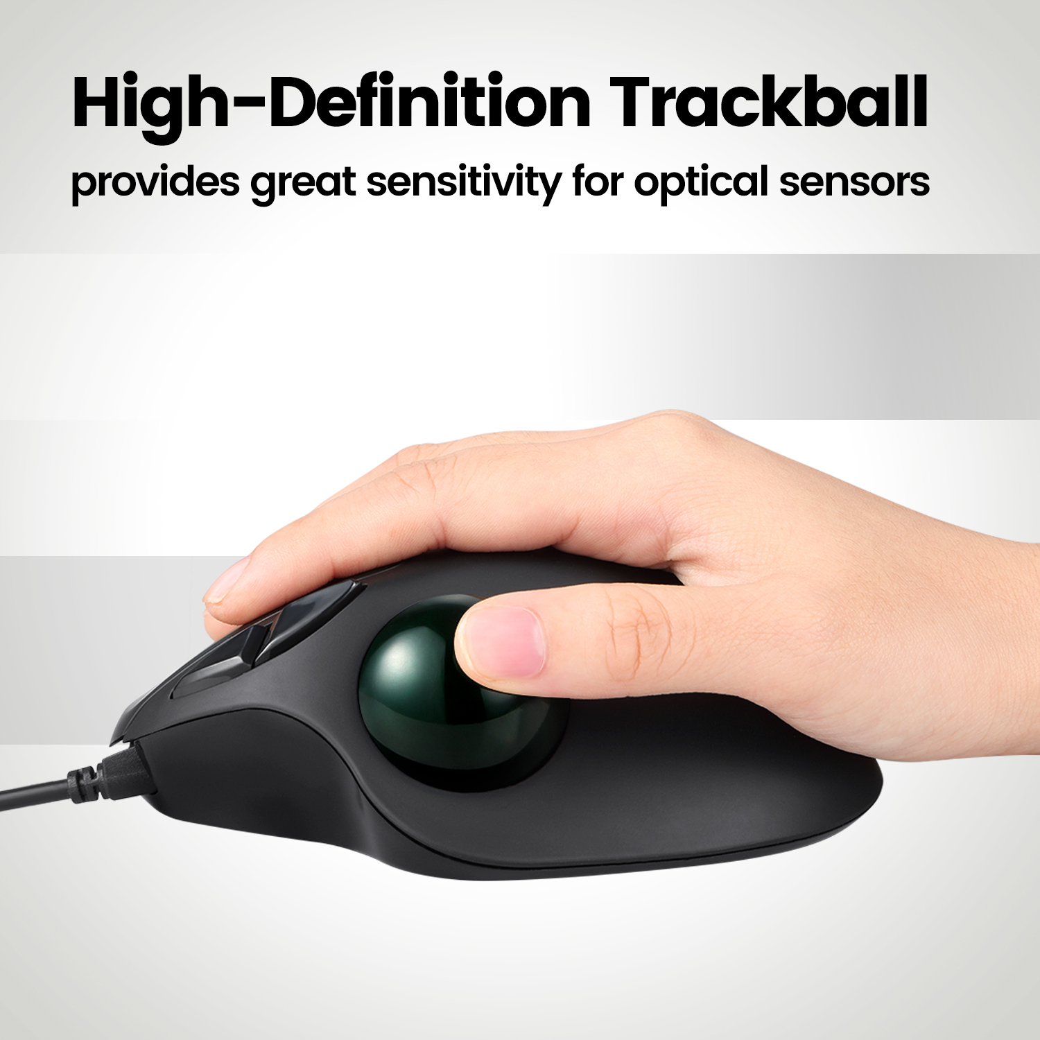 Die Hand einer Person, die eine schwarze Trackball-Maus mit einer grünen Kugel hält, auf weißem und grauem Hintergrund.