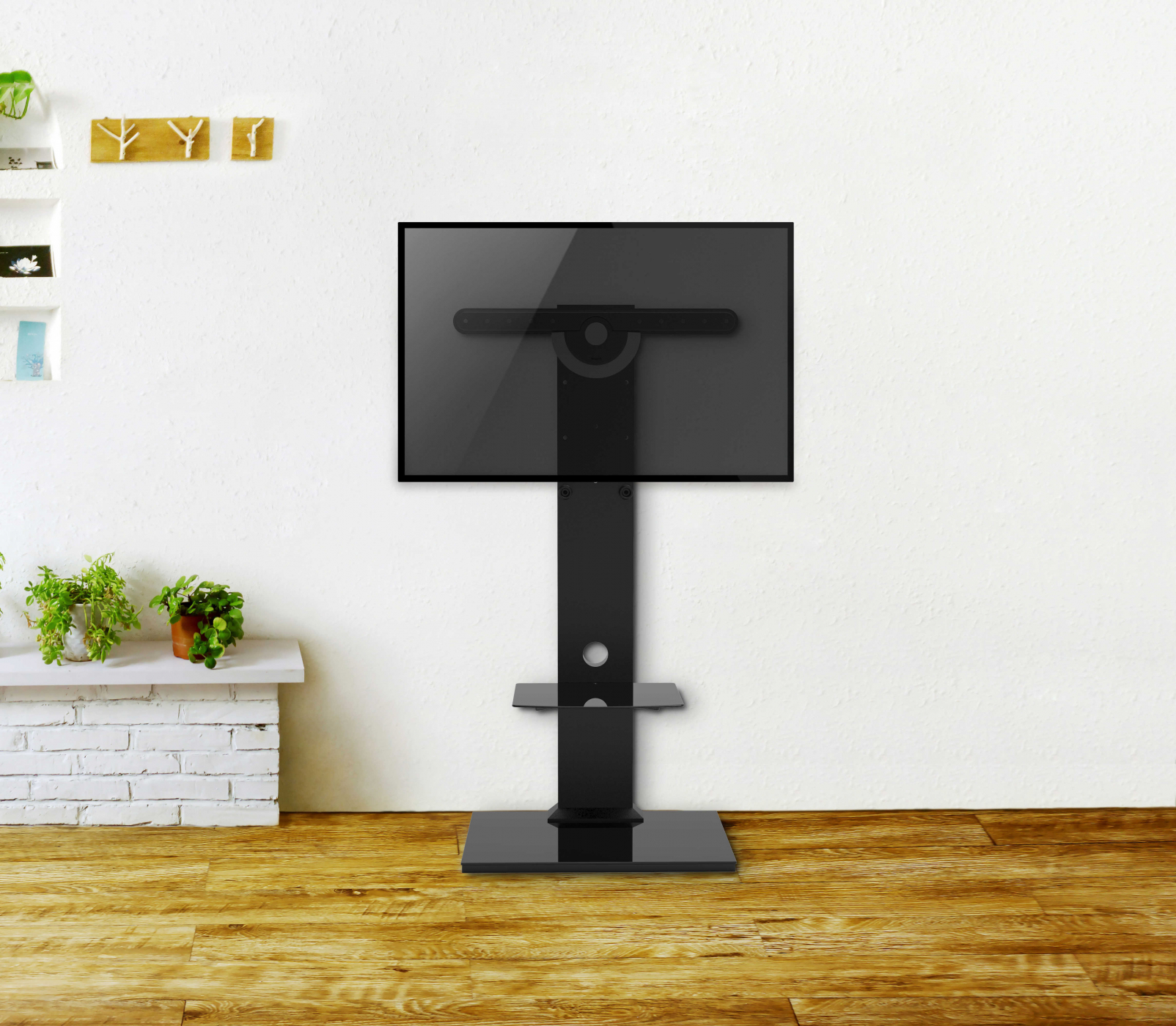 Ein schwarzer TV-Ständer mit einem Fernseher, in einem Raum mit weißer Wand und Holzboden.
