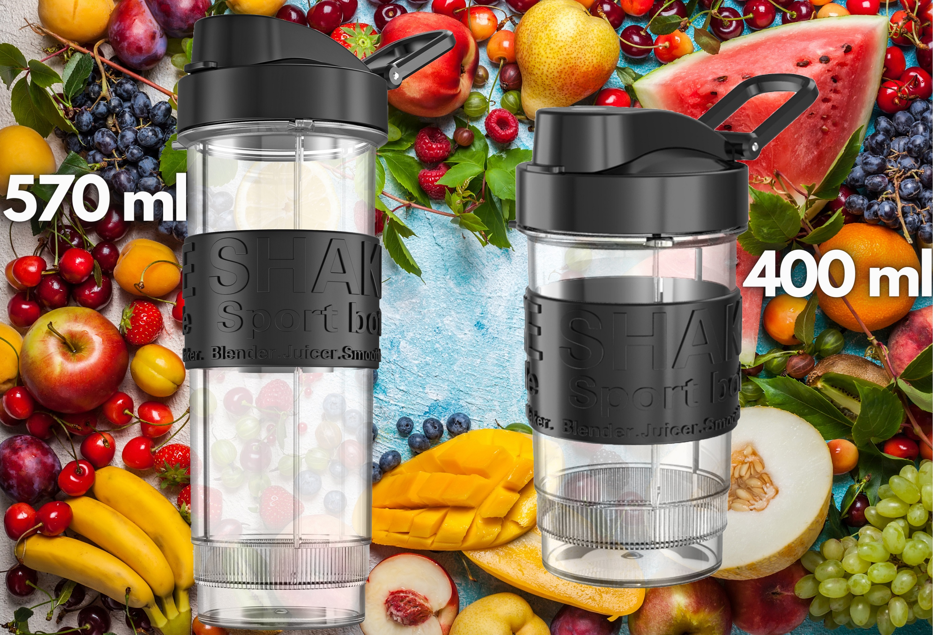 Dwie przezroczyste butelki do blendera. Jedna ma etykietę 570 ml, druga 400 ml. Owoce w tle.