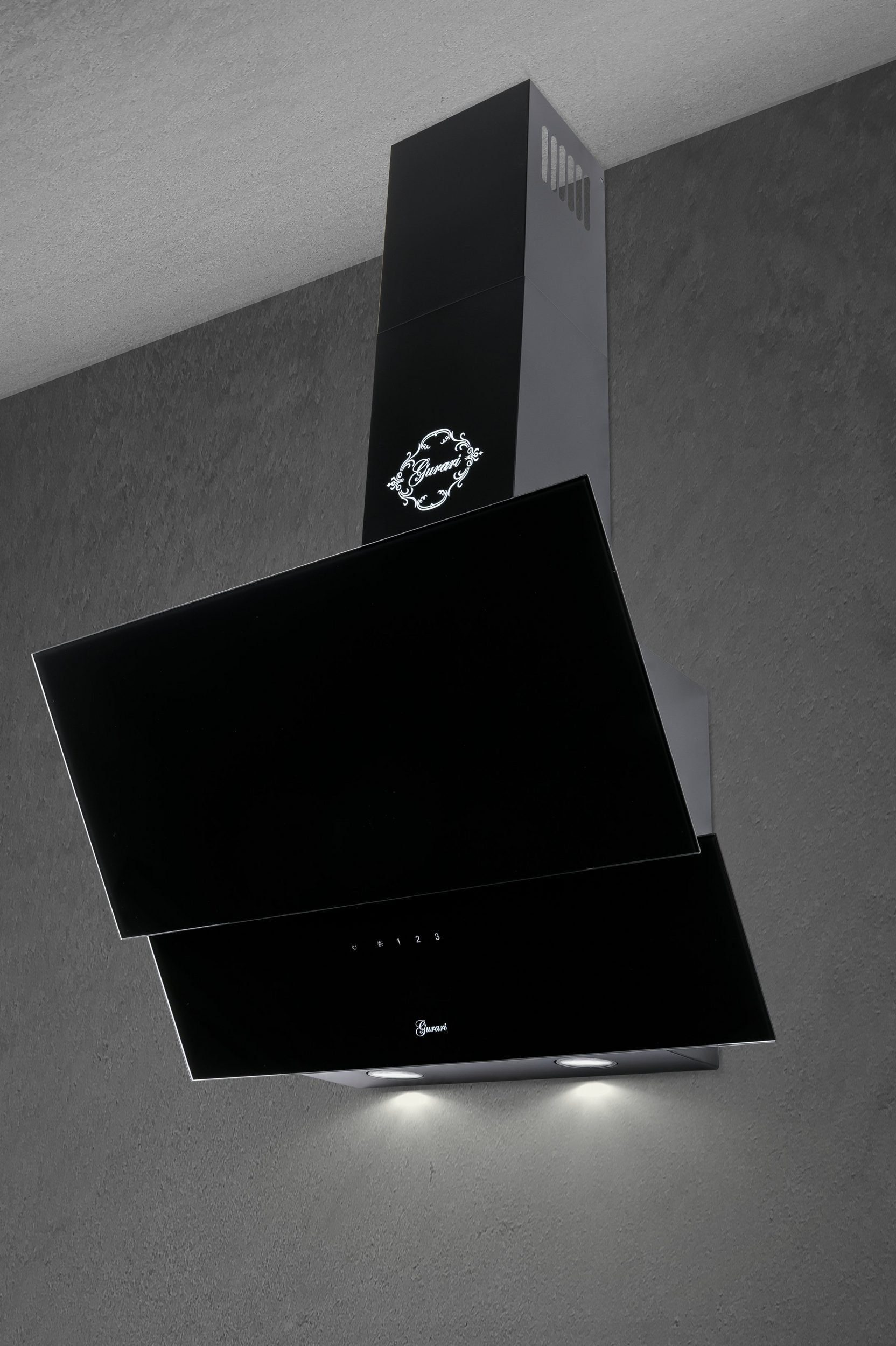 Una campana extractora negra con un emblema plateado en una pared gris.