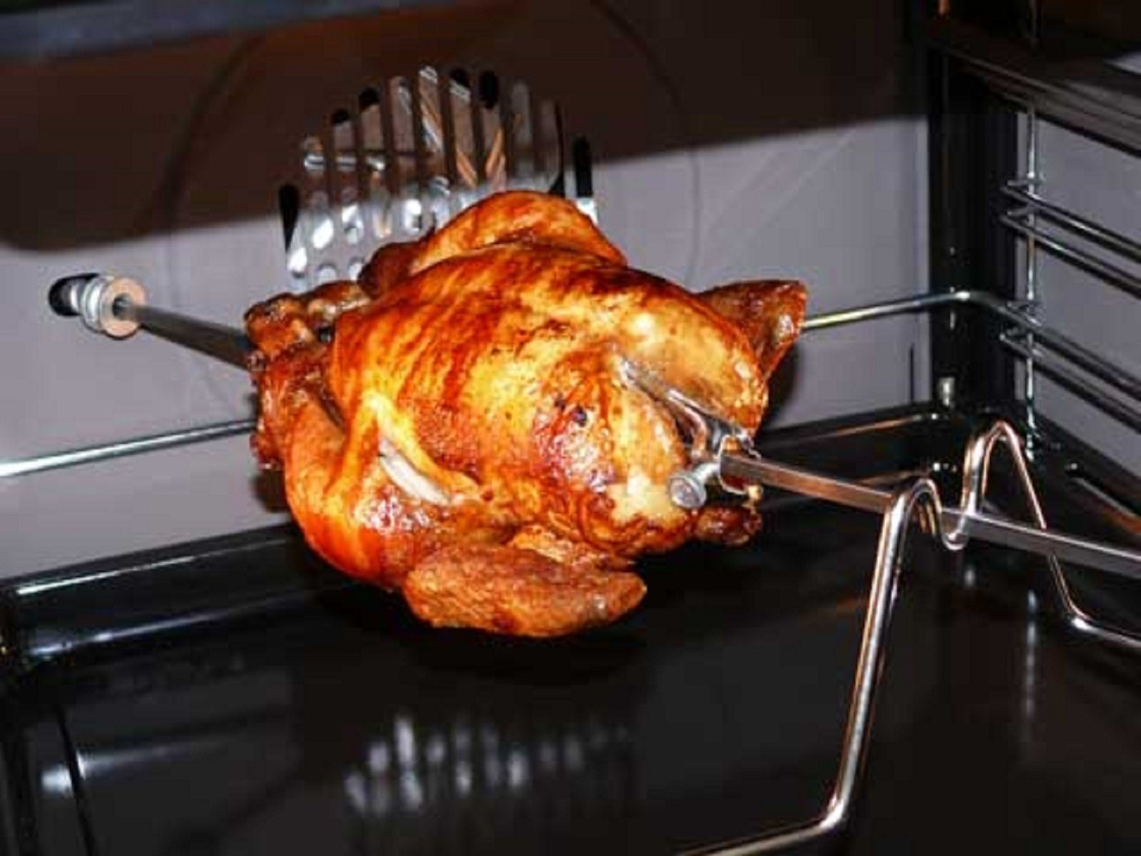 Ein gebratenes Huhn, das sich in einem Ofen dreht.