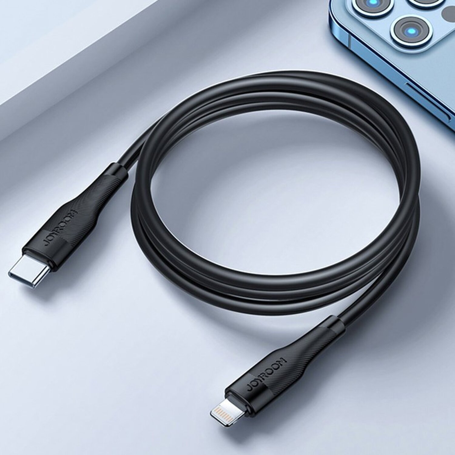 Schwarzes USB-C-zu-Lightning-Kabel. Ein Ende ist USB-C, das andere Lightning, auf weißer Oberfläche.