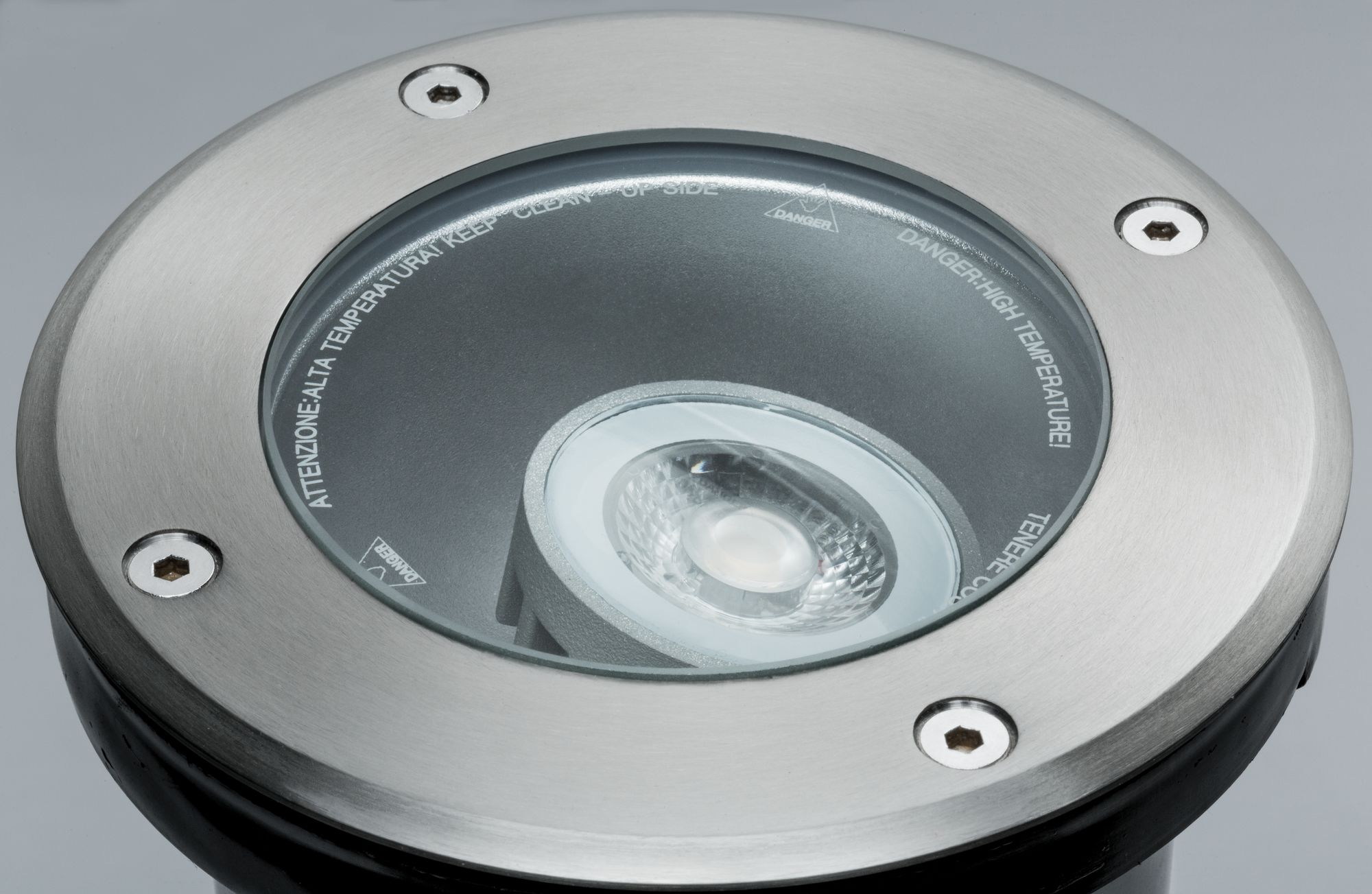Zewnętrzna oprawa oświetleniowa wpuszczana, srebrna i czarna, z tekstem ostrzegawczym.