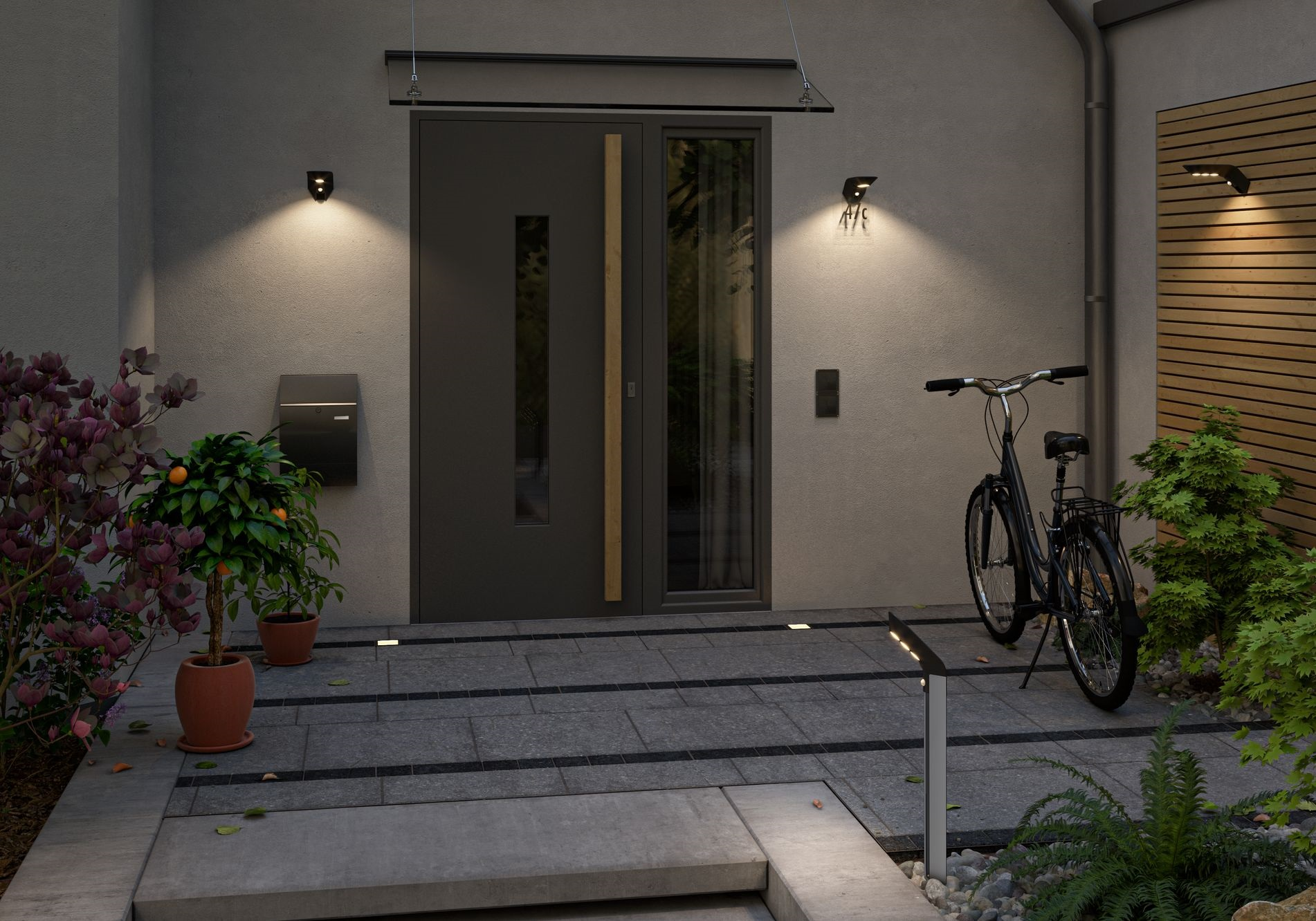 Widok zewnętrzny domu z drzwiami wejściowymi, roślinami i rowerem.