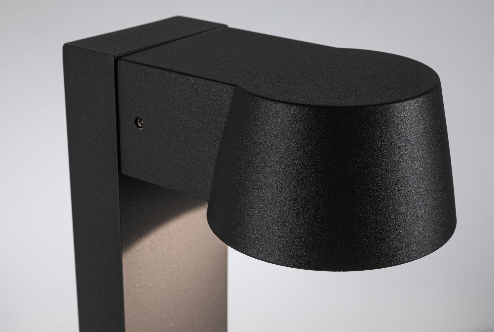 Czarna lampa zewnętrzna. Lampa ma kwadratową podstawę i zaokrąglony wierzch.