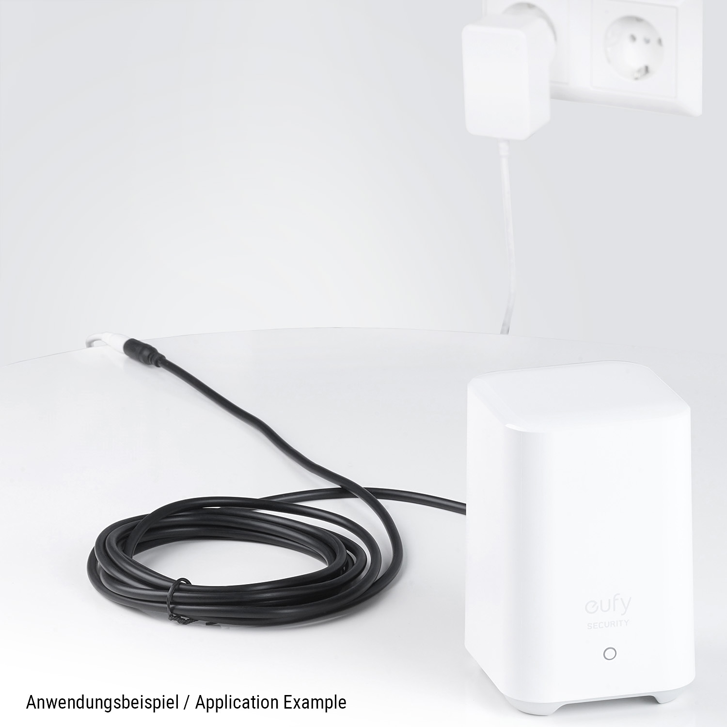 Ein weißes Smart-Home-Gerät mit schwarzem Kabel. Eine Steckdose im Hintergrund. Text 'Anwendungsbeispiel'.