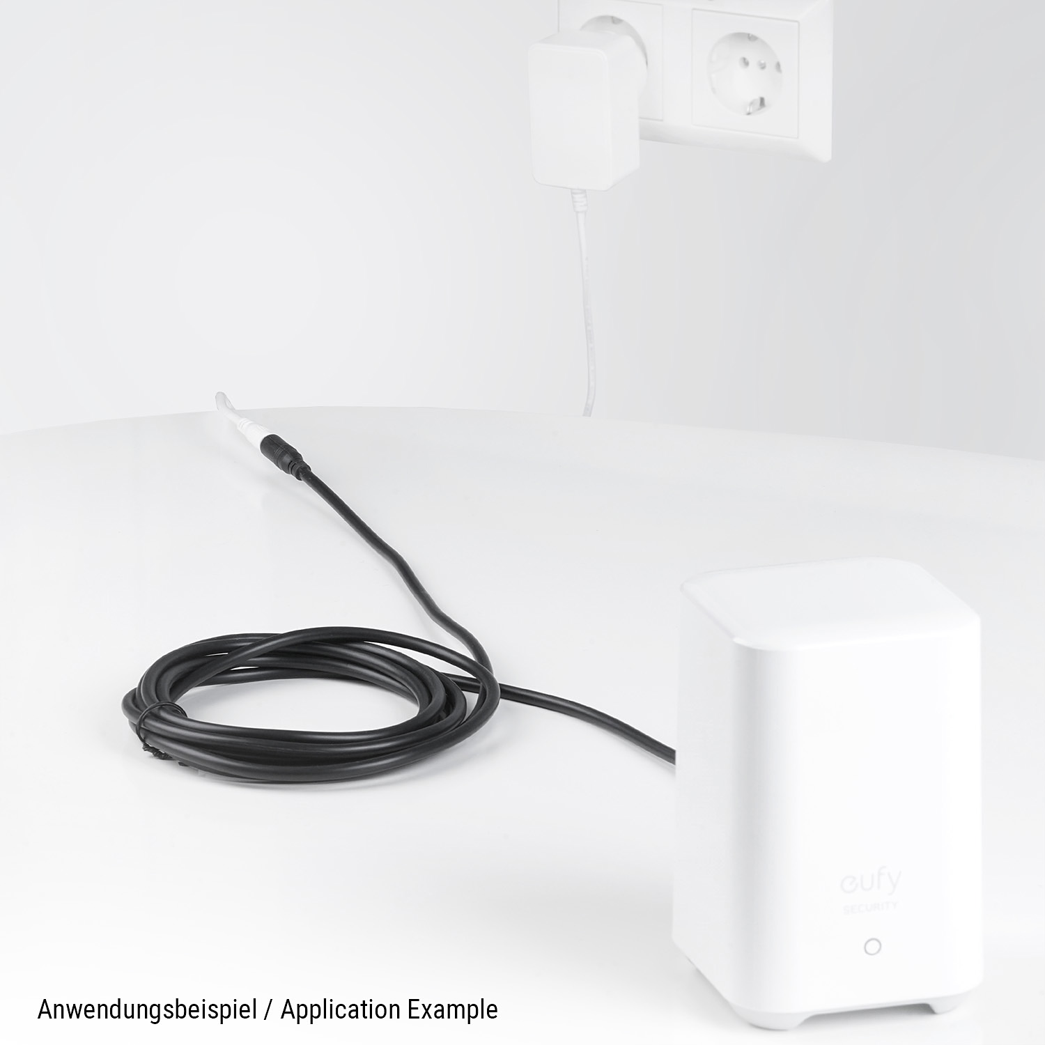 Ein weißes Gerät und ein Netzteil, die mit einem Kabel verbunden sind, das an einer Steckdose angeschlossen ist.