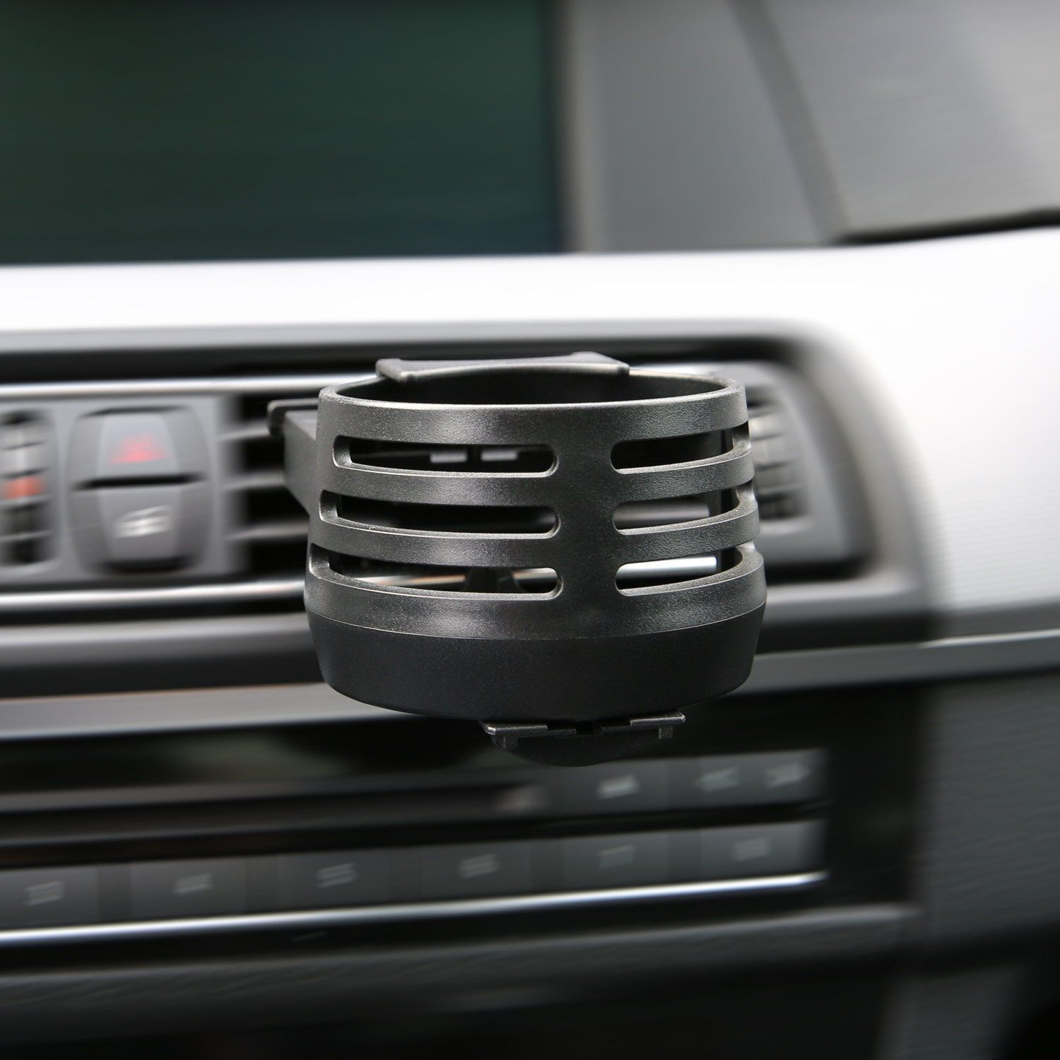 Schwarzer Auto-Getränkehalter in einem Auto. Er ist in der Lüftung installiert. Verschwommener Hintergrund.