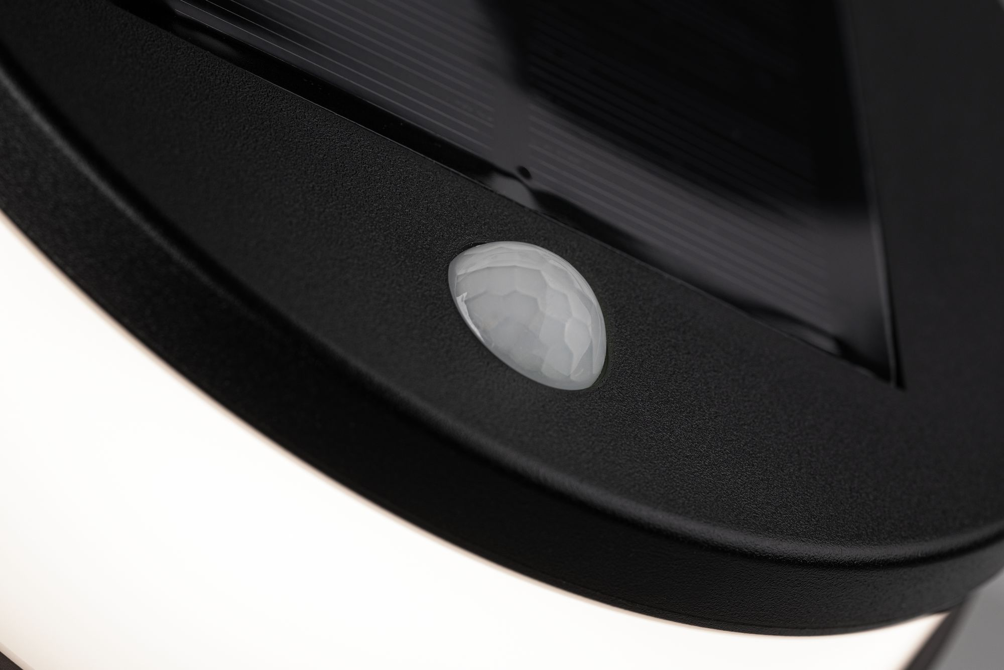 Zbliżenie czujnika, z białą obwódką. Czarna powierzchnia.