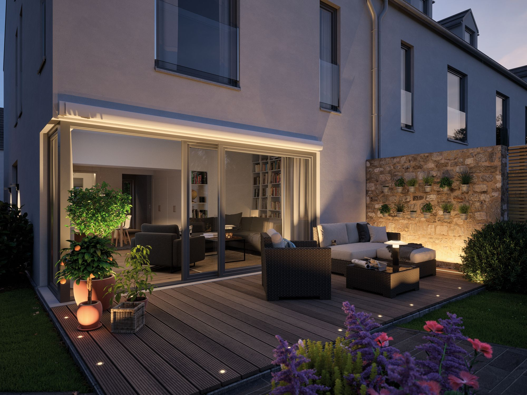 Nowoczesny dom na zewnątrz o zmierzchu, z drewnianym tarasem, meblami ogrodowymi i oświetleniem ogrodu.