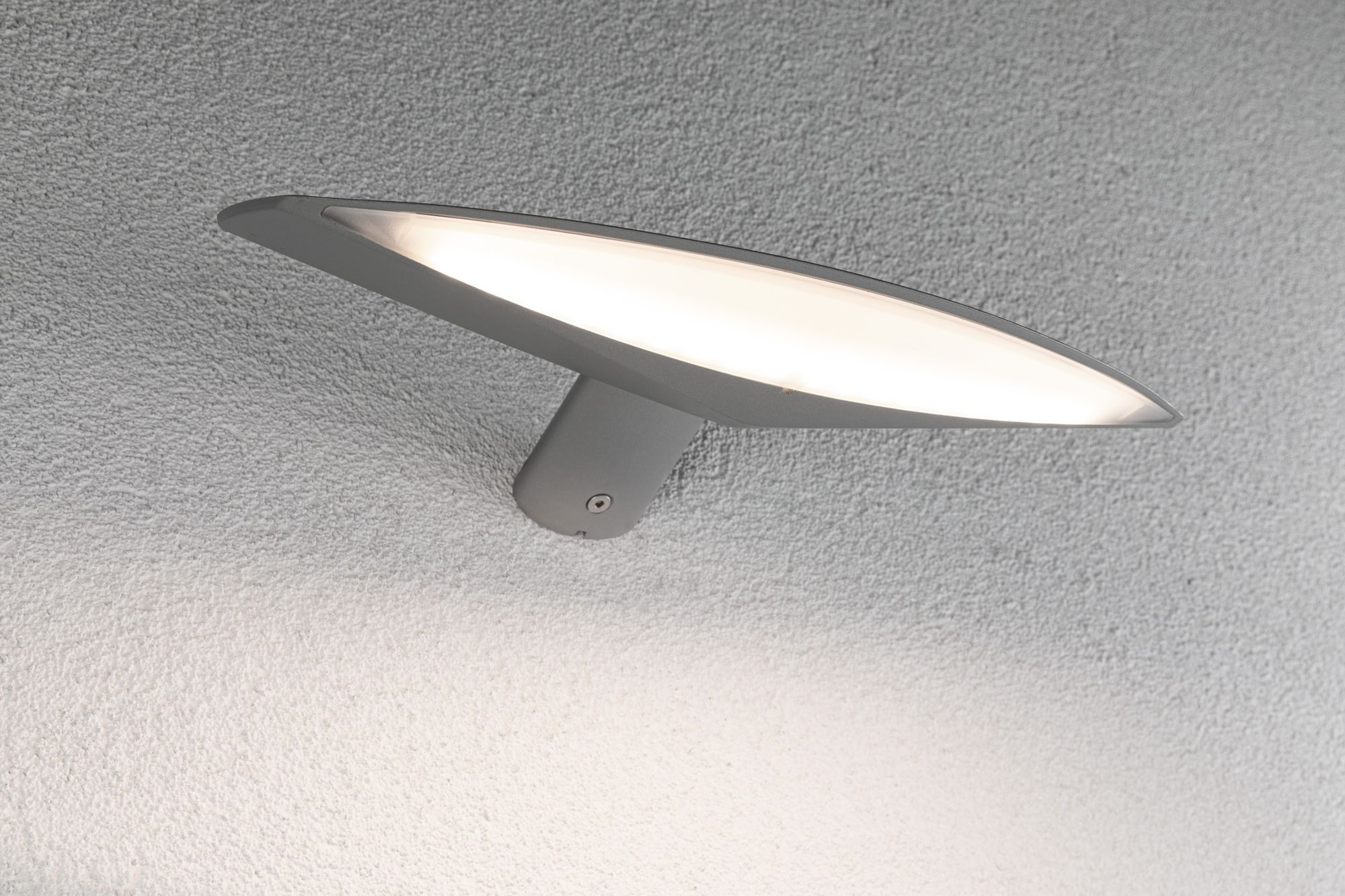 Graue Wandleuchte mit geschwungenem Design, an einer strukturierten Wand montiert.