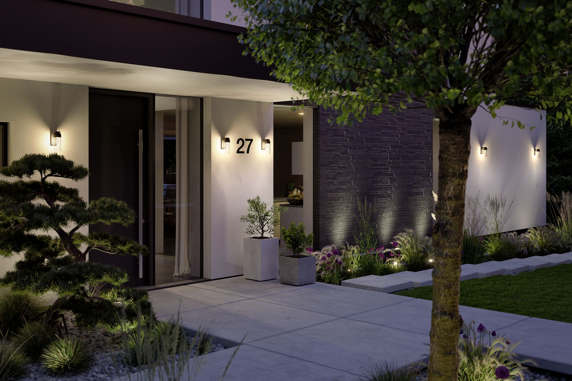 Nowoczesny dom na zewnątrz o zmierzchu z oświetlonym wejściem, roślinami i oświetleniem ogrodowym. Widoczny numer 27.