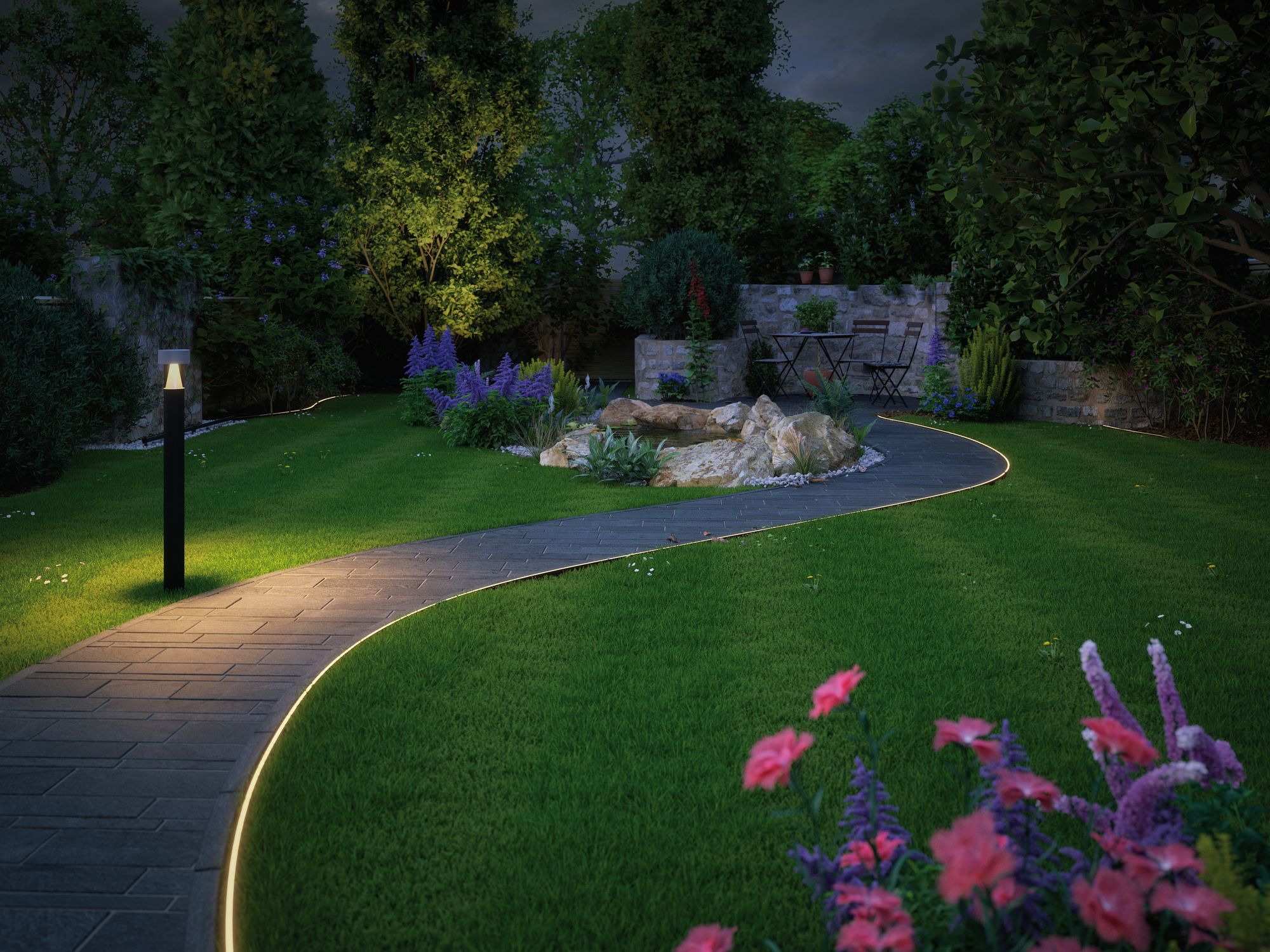 Eine Gartenszene bei Nacht. Ein Steinweg schlängelt sich durch grünes Gras, beleuchtet von kleinen Lichtern. Bäume und Blumen sind sichtbar.