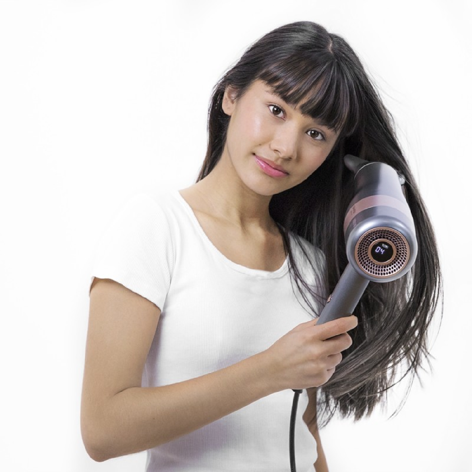 Donna con i capelli lunghi che usa un asciugacapelli, sfondo bianco.