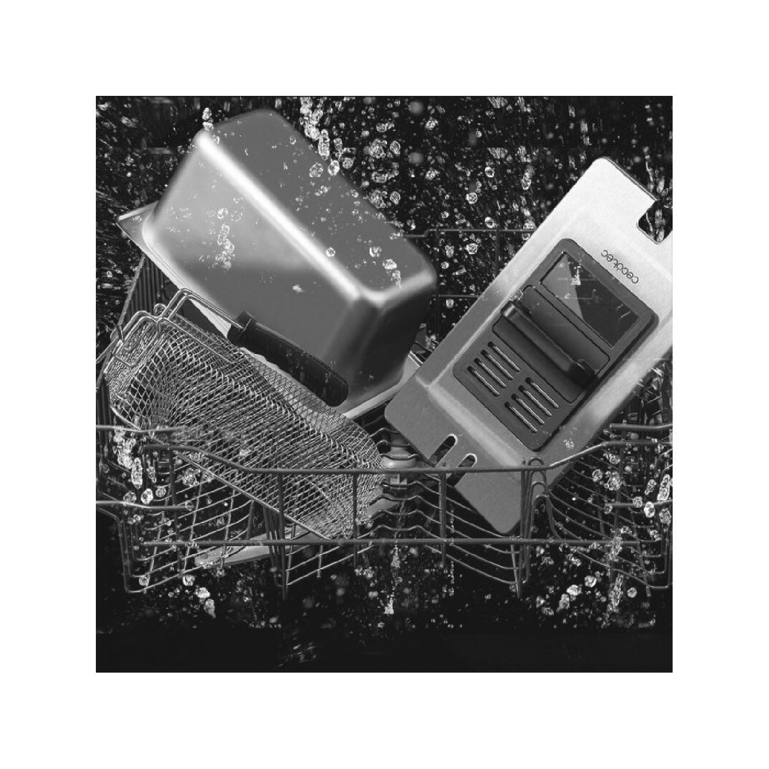 Metalowy kosz z przyborami kuchennymi w zmywarce. Widoczne są krople wody.