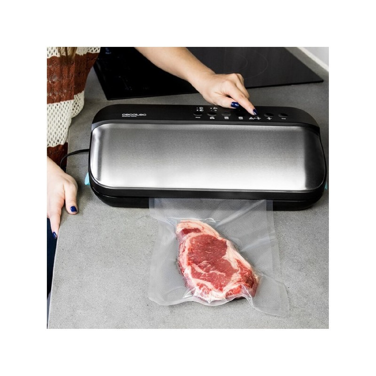 Kobieta obsługuje zgrzewarkę próżniową z surowym stekiem w przezroczystej torbie. Czarne urządzenie na blacie.