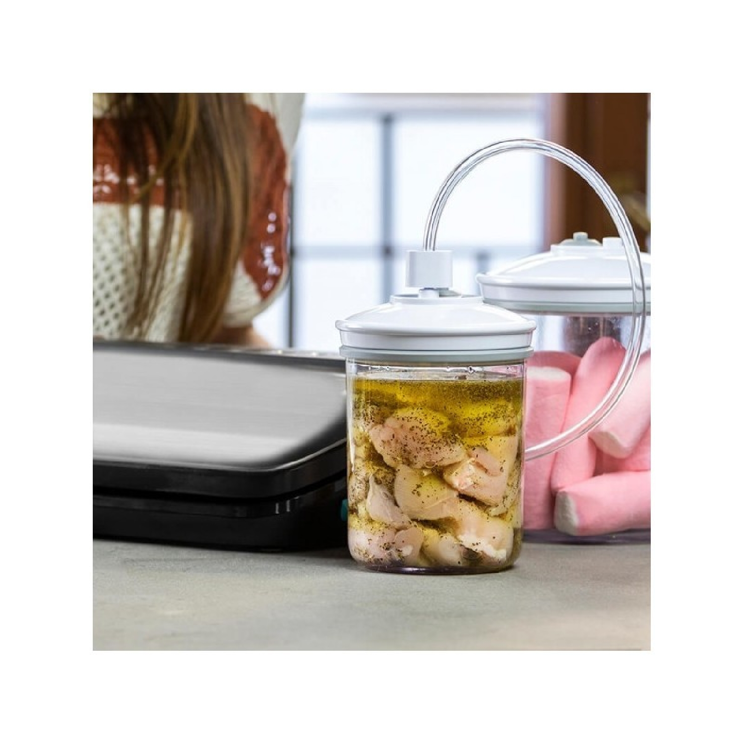 Słoik z gotowanym kurczakiem i olejem, drugi słoik z różowymi przedmiotami, ramię kobiety w tle.