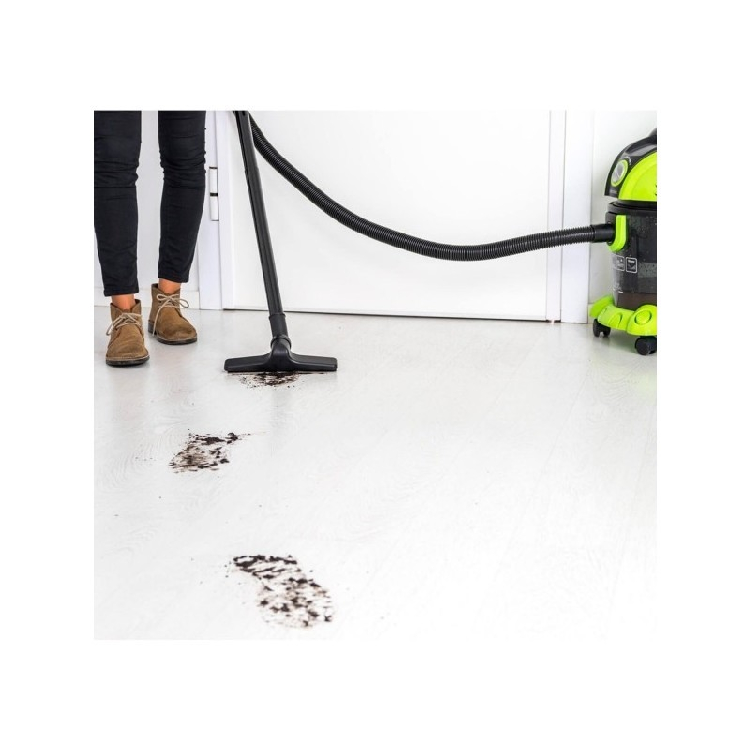 A woman using a vacuum cleaner, with footprints on the floor.