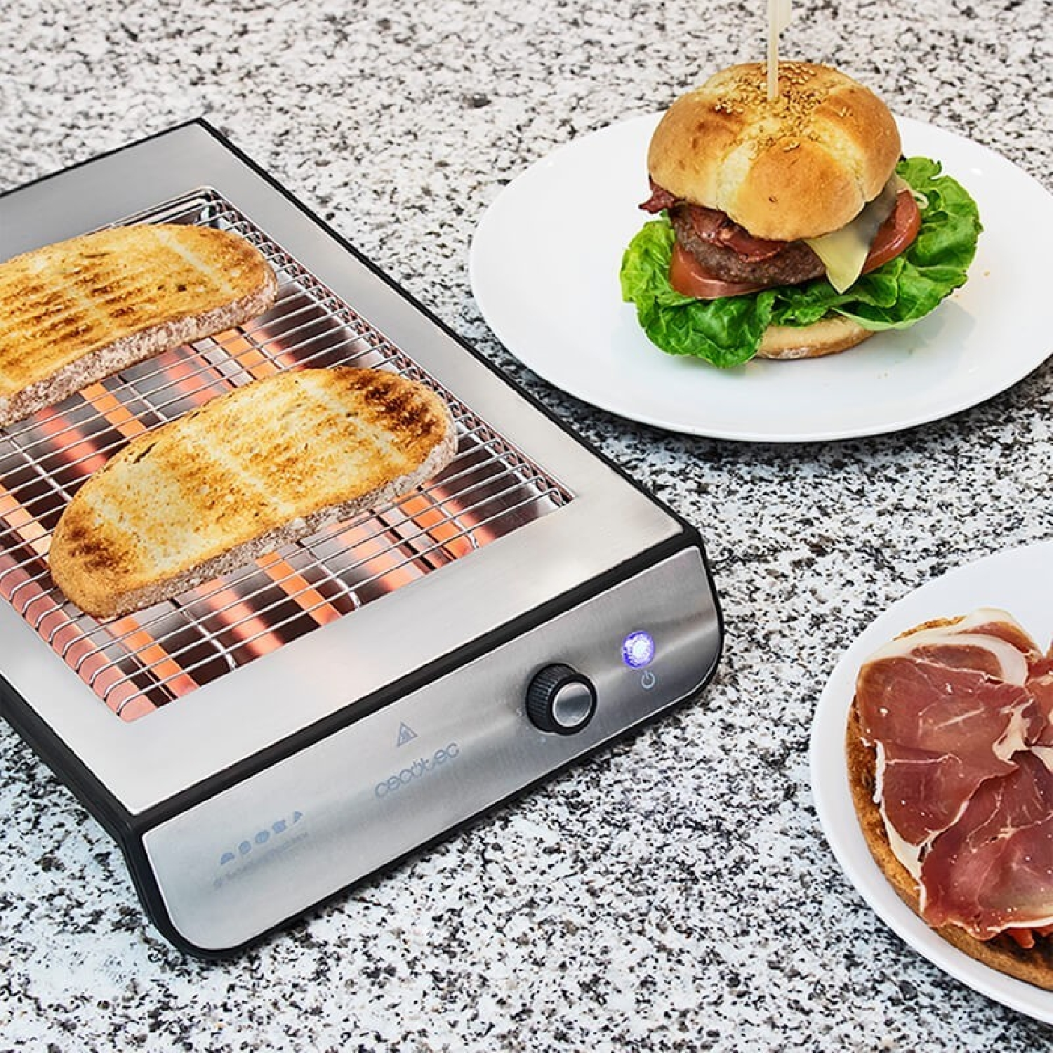 Broodrooster met twee sneetjes toast, een burger en een sandwich op borden. De broodrooster staat aan.