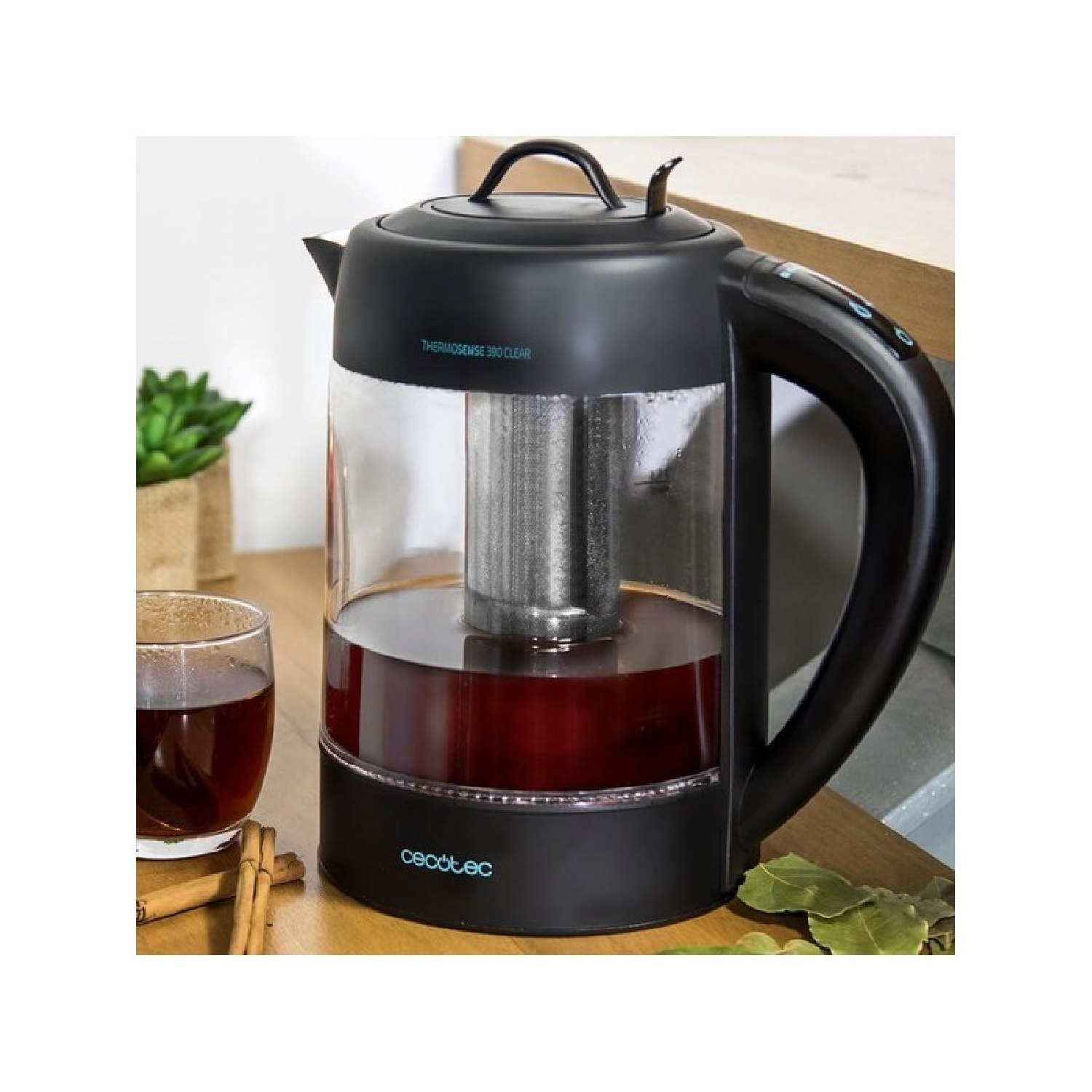 Hervidor eléctrico negro con cuerpo de vidrio, que contiene té, y filtro de acero inoxidable.