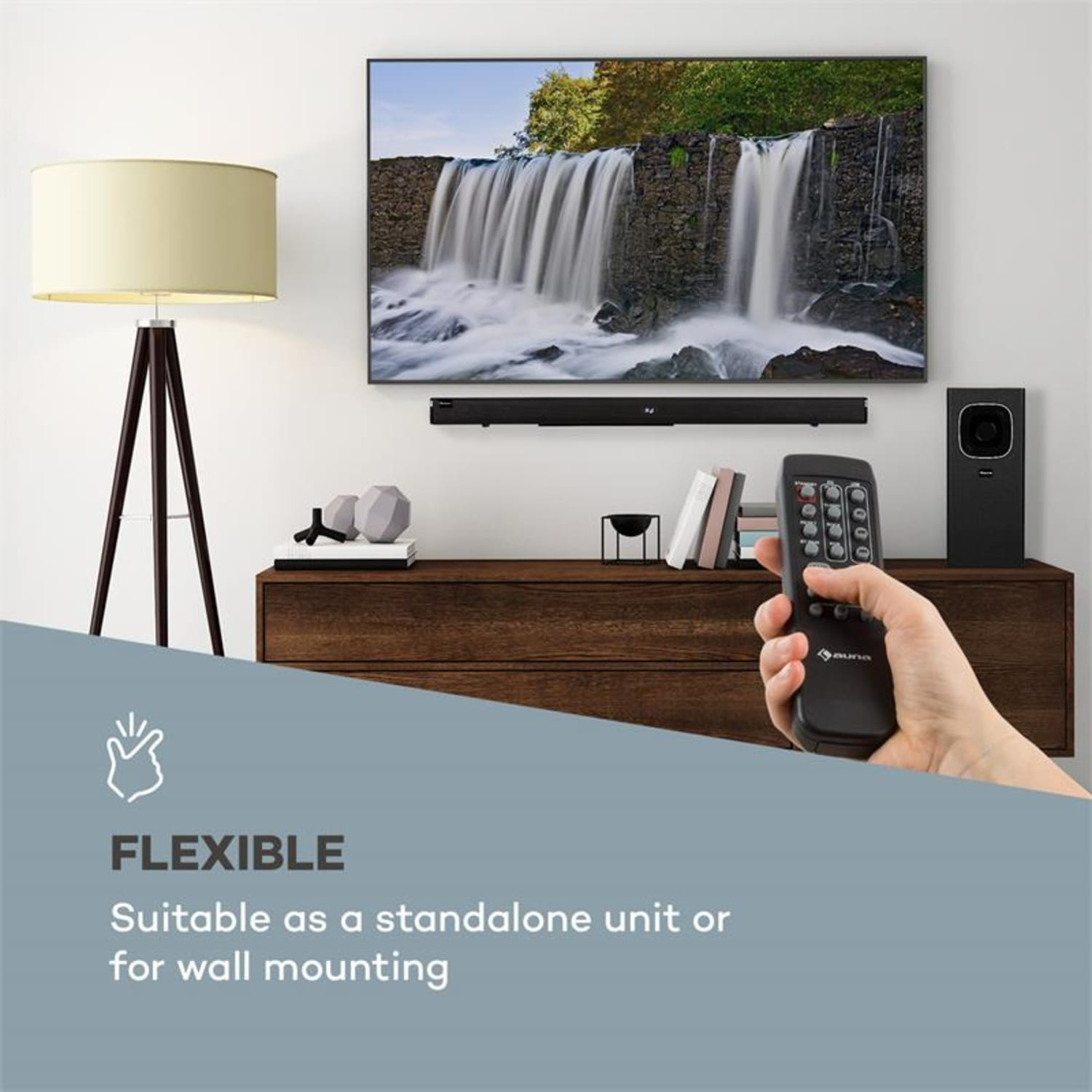 Ein Fernseher mit Wasserfallbild, eine Soundbar, eine Fernbedienung und ein Lautsprecher sind zu sehen.