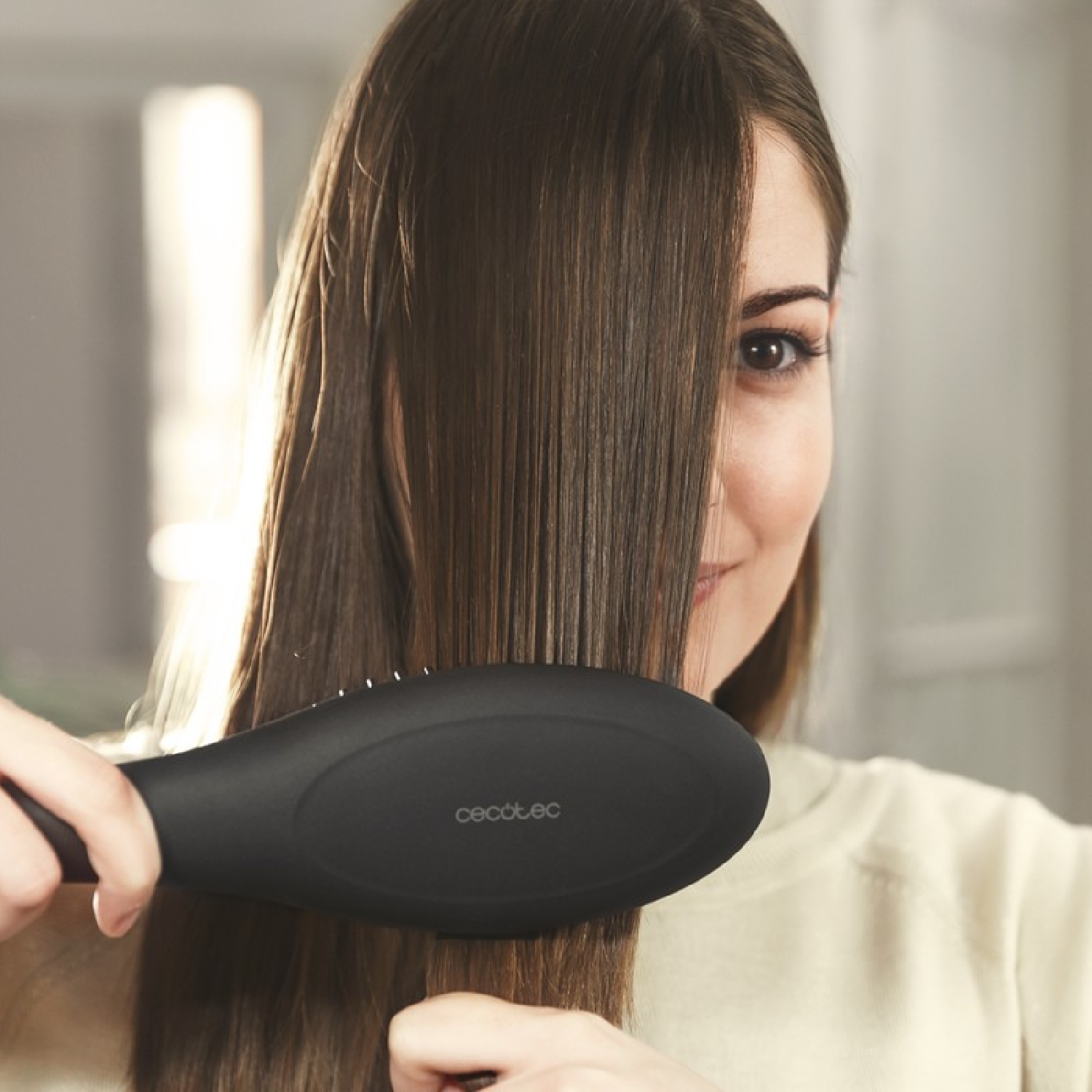 Een vrouw die haar haar borstelt met een zwarte stijltangborstel.