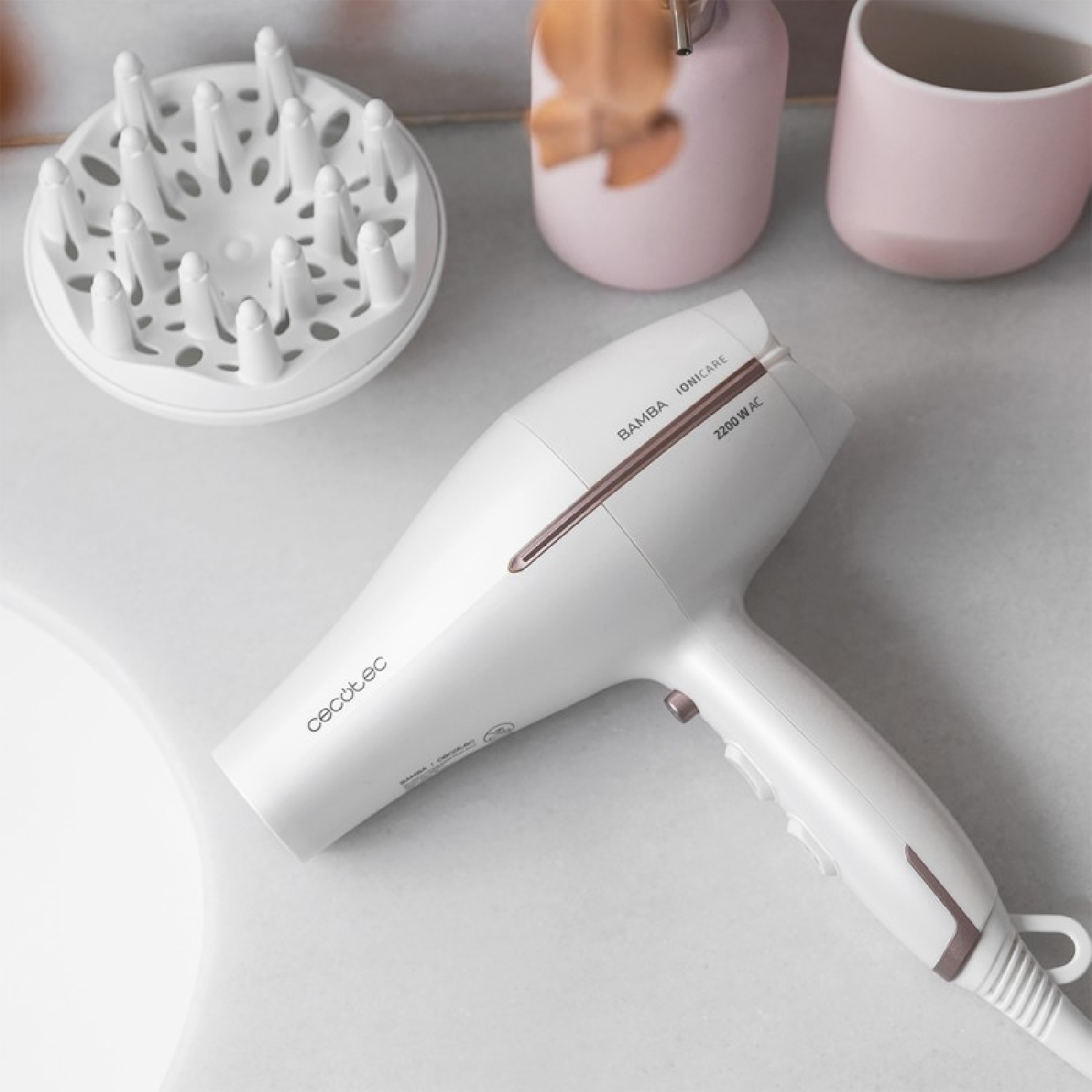 Asciugacapelli bianco con diffusore su una superficie bianca con altri oggetti.