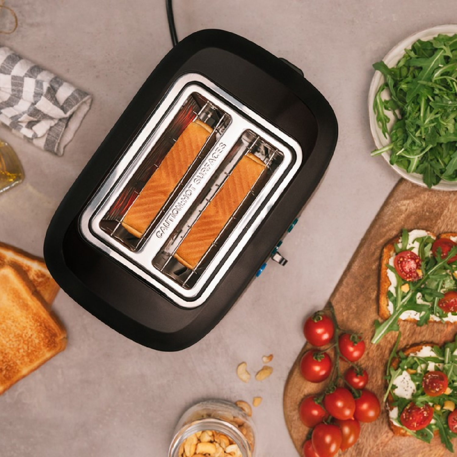 A black toaster with two slots. There are two slices of toast inside. The background is a countertop.