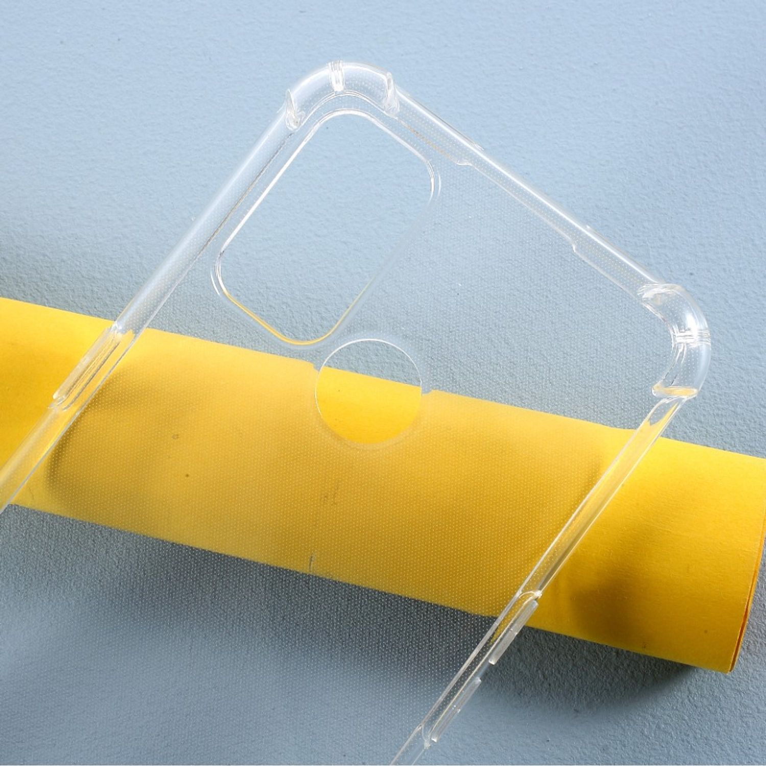 Transparente Handyhülle auf gelbem Papier. Die Hülle ist leer und zeigt den Kameraausschnitt.