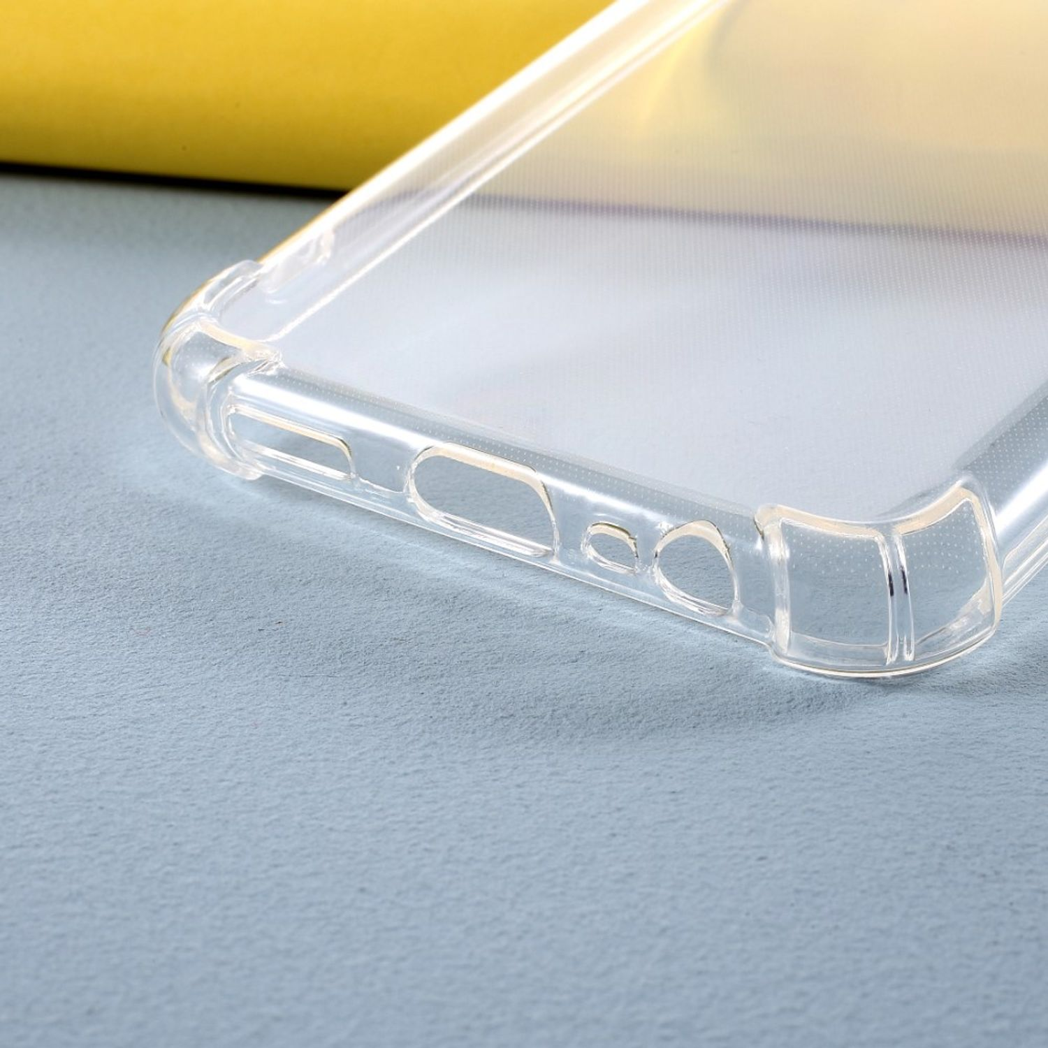 Transparente Handyhülle auf blauer Oberfläche, mit Aussparungen für Knöpfe und Anschlüsse.