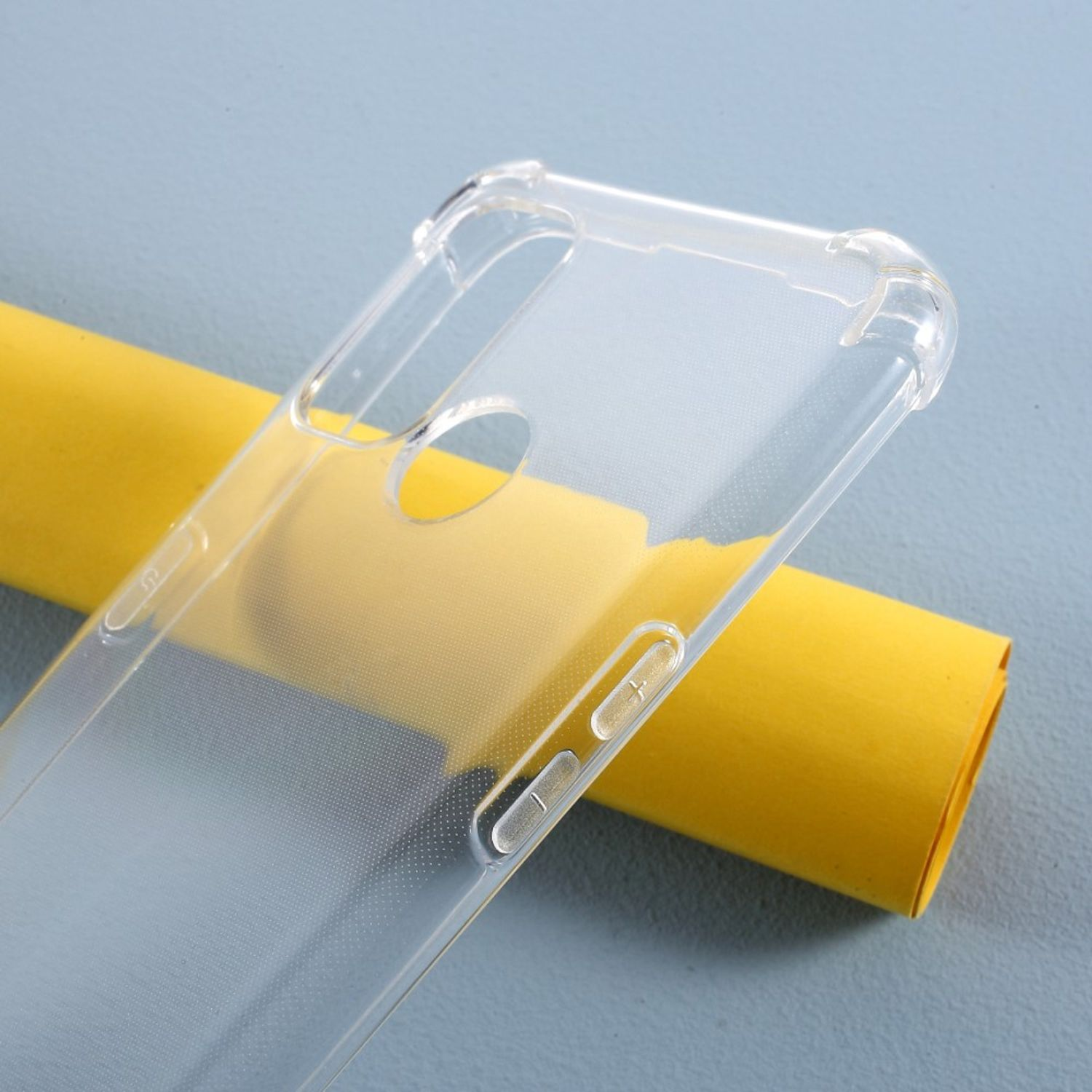 Eine klare, transparente Handyhülle liegt auf einer gelben Papierrolle, abgewinkelt, um Details zu zeigen.