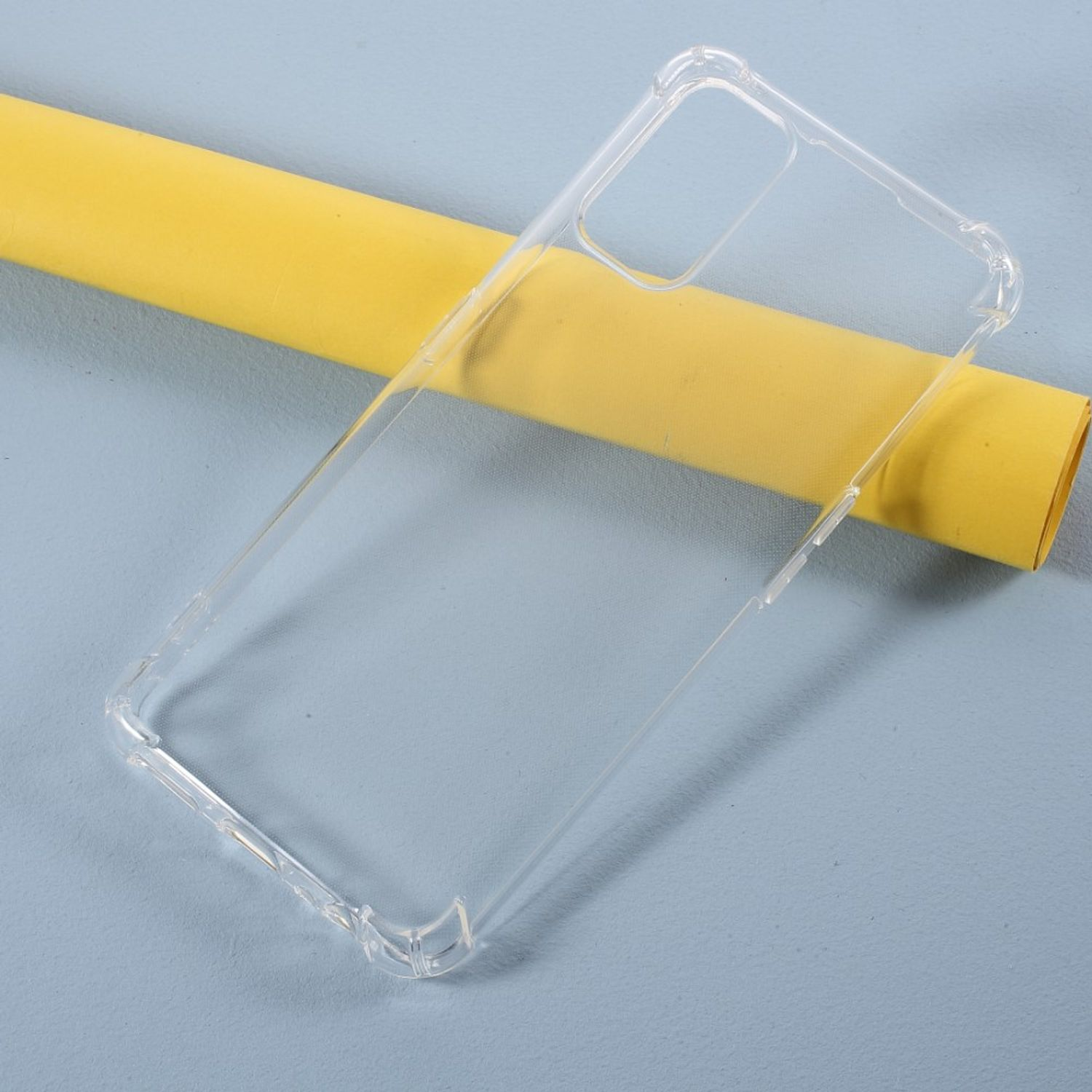 Eine transparente Handyhülle auf blauem Untergrund, mit einer gelben Rolle im Hintergrund.
