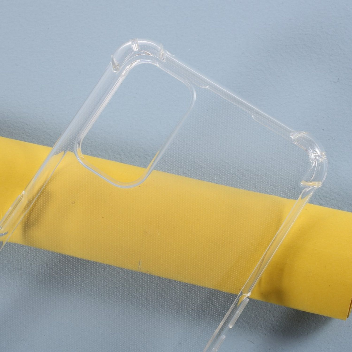Transparente Handyhülle auf gelber Oberfläche. Die Hülle hat abgerundete Kanten und ein Kamera Loch.