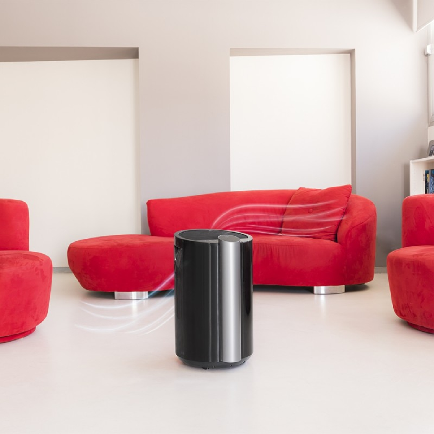 Czarny oczyszczacz powietrza w czerwonym pokoju. Czerwona sofa i krzesła. Widoczne linie przepływu powietrza.