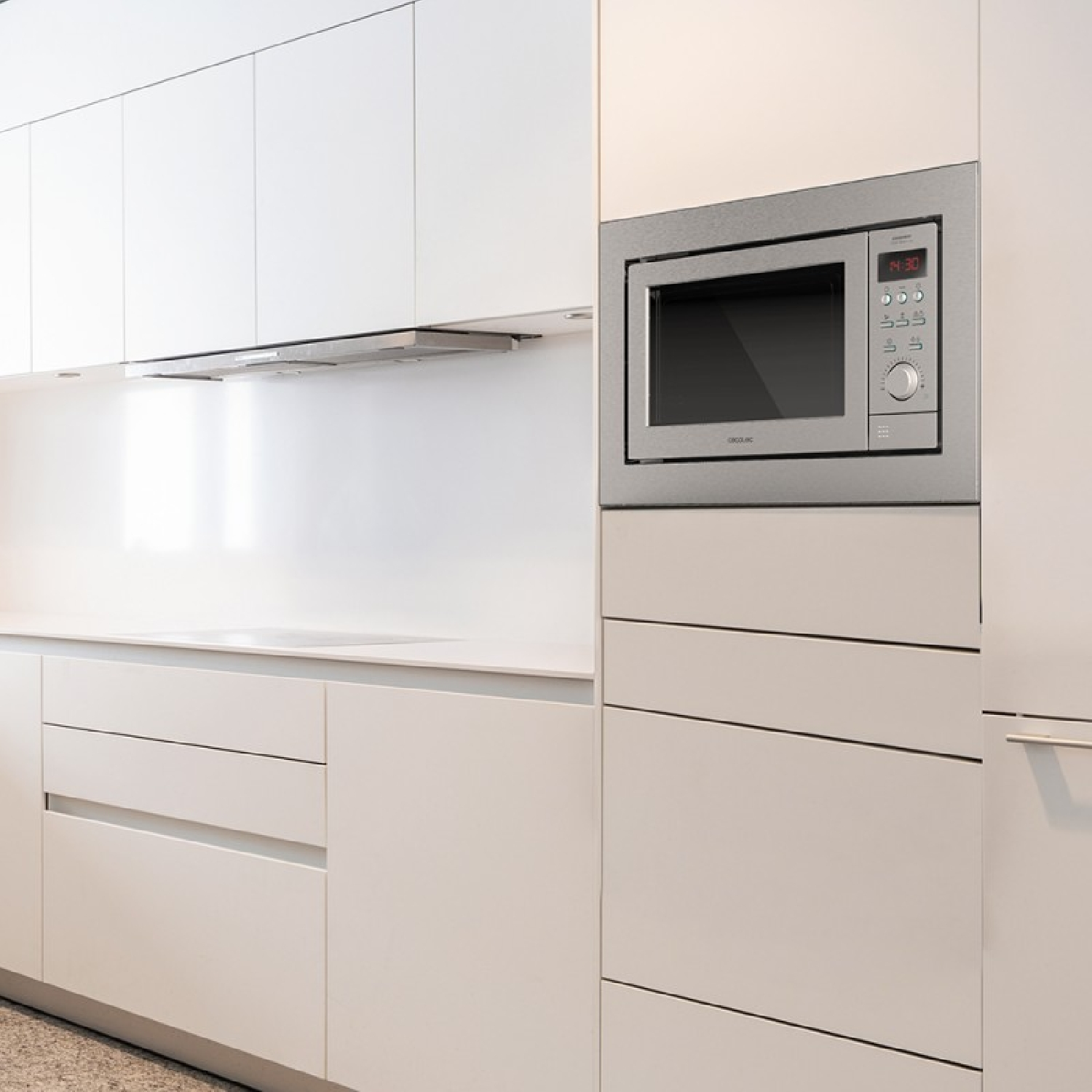 Nowoczesna biała kuchnia z wbudowaną kuchenką mikrofalową i szafkami.